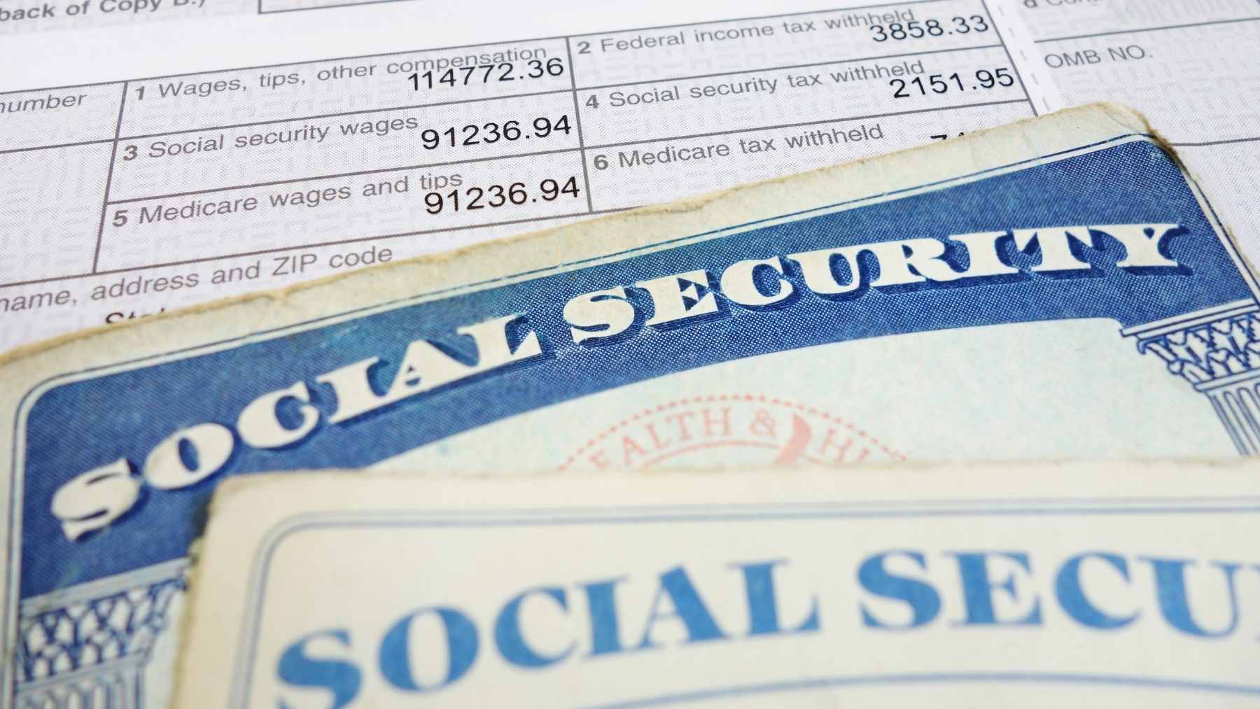 Social Security card on a tax form; image to illustrate COLA 2026 and its impact on payments.