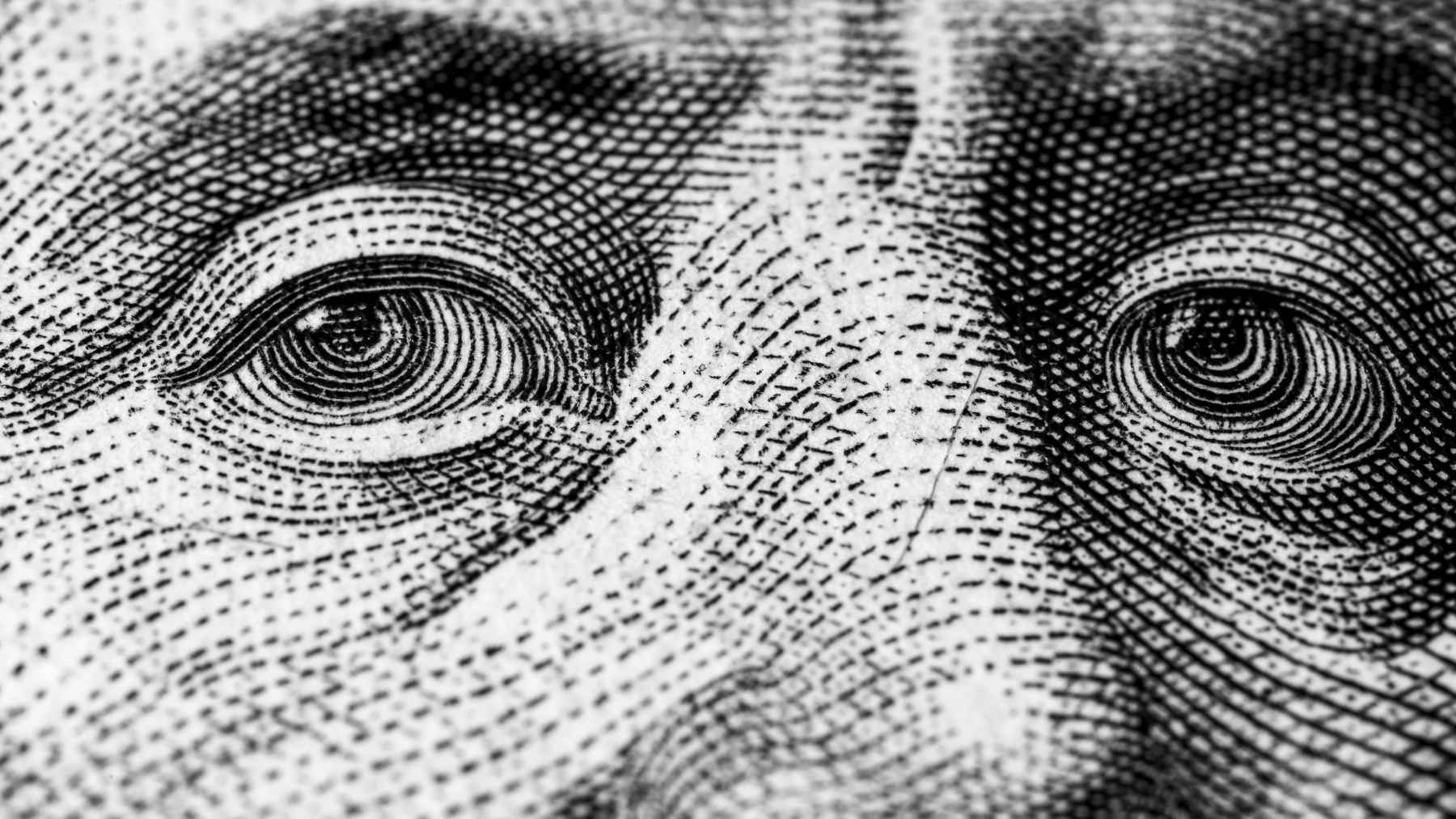 Close-up of an engraved U.S. banknote portrait, symbolizing wealthy Americans shifting cash out of checking accounts.
