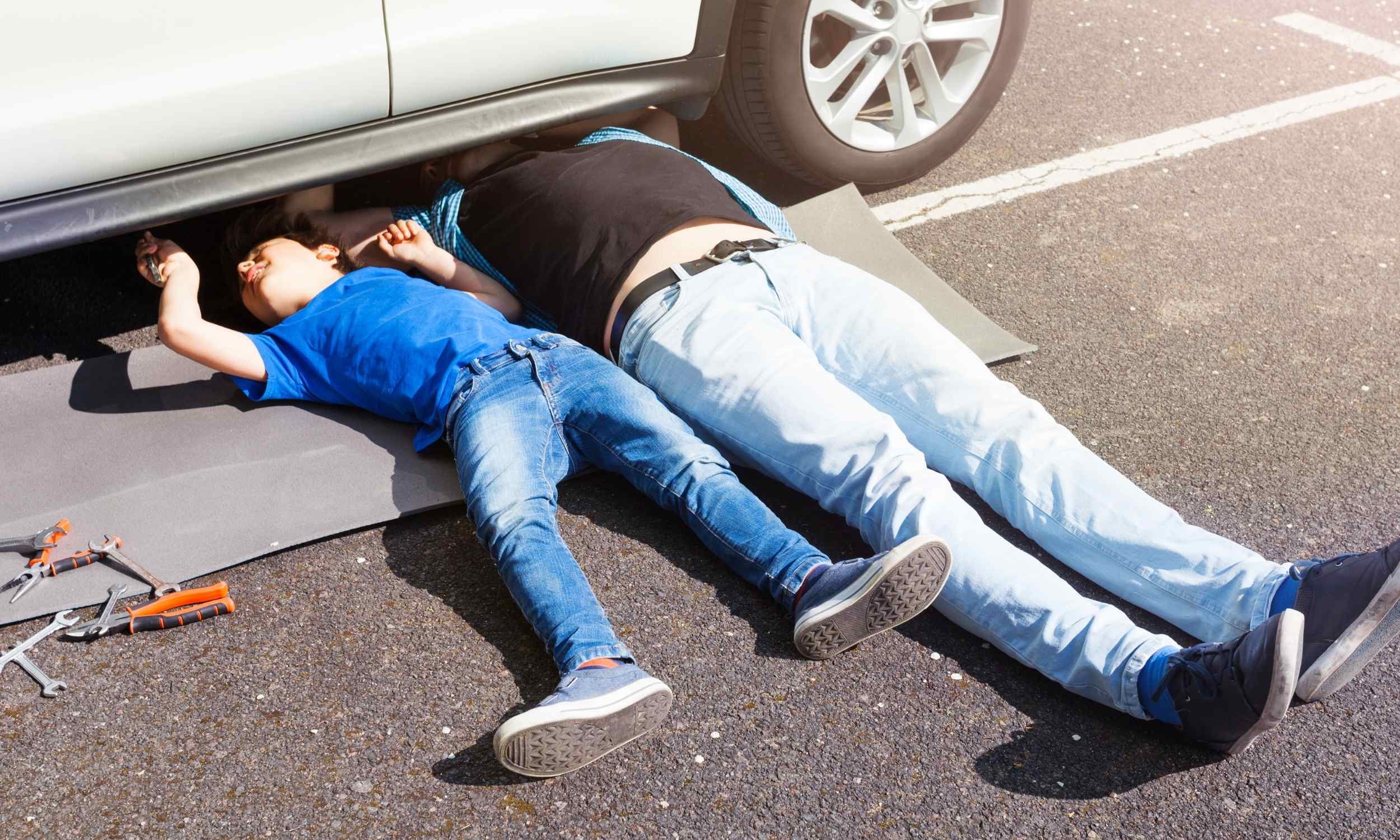 Father and child working under a car, highlighting skilled trades as an alternative to a four-year college path.