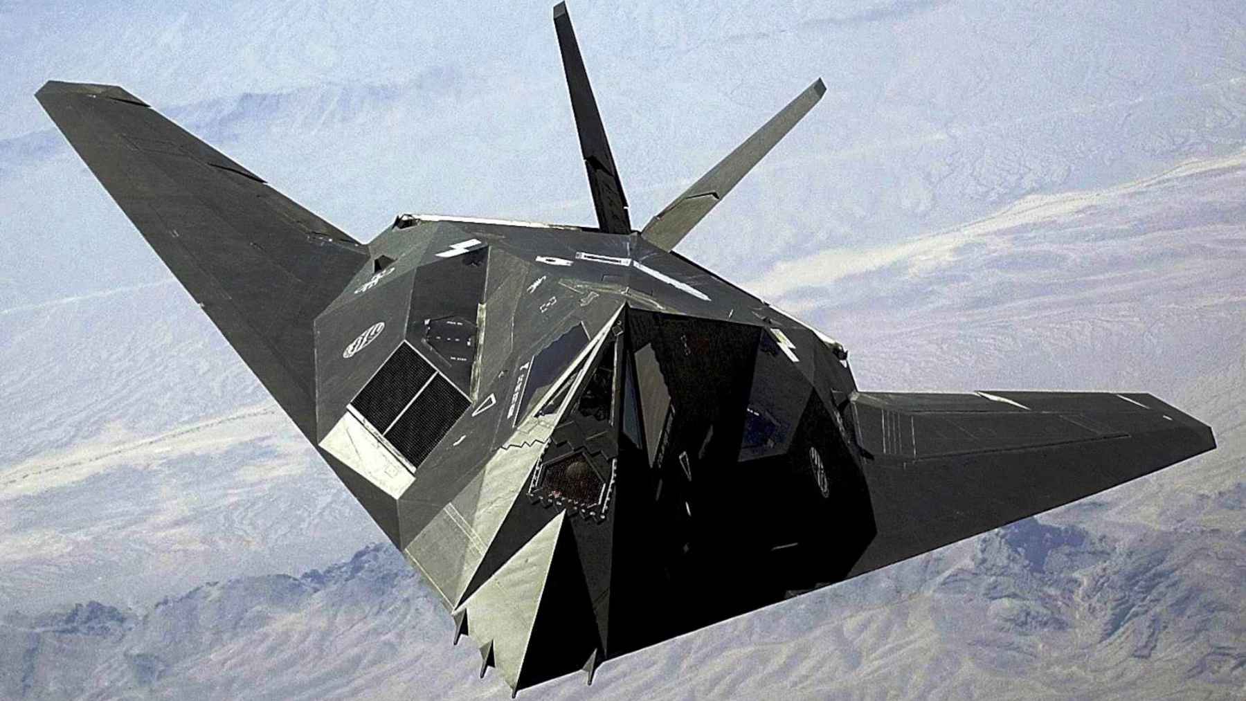 A US Air Force F-117 Nighthawk stealth aircraft flies over the Nevada desert during a training mission.