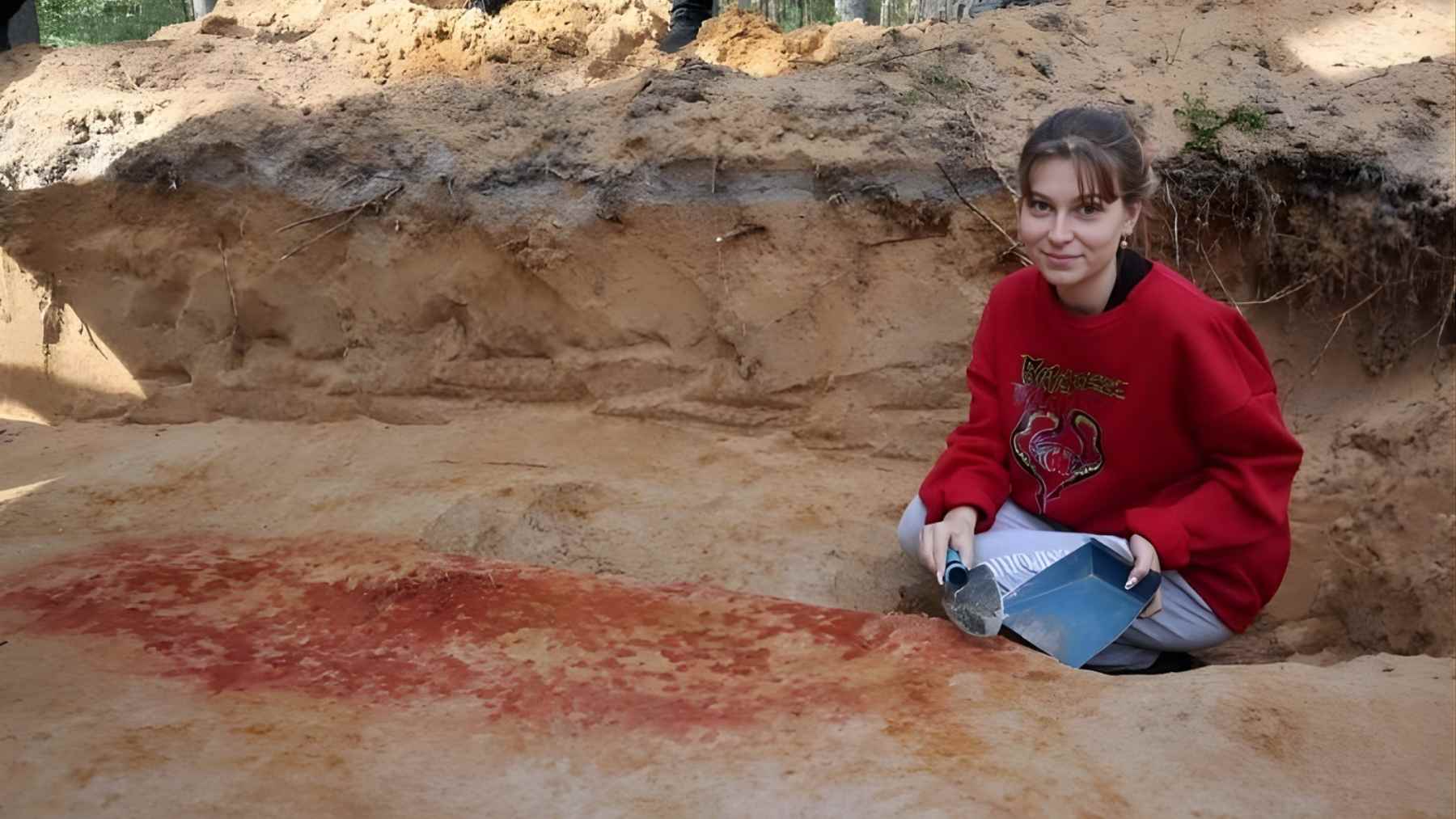 Student archaeologist documents a red-ochre burial pit linked to a 5,400-year-old amber grave near Lake Onega, Russia.