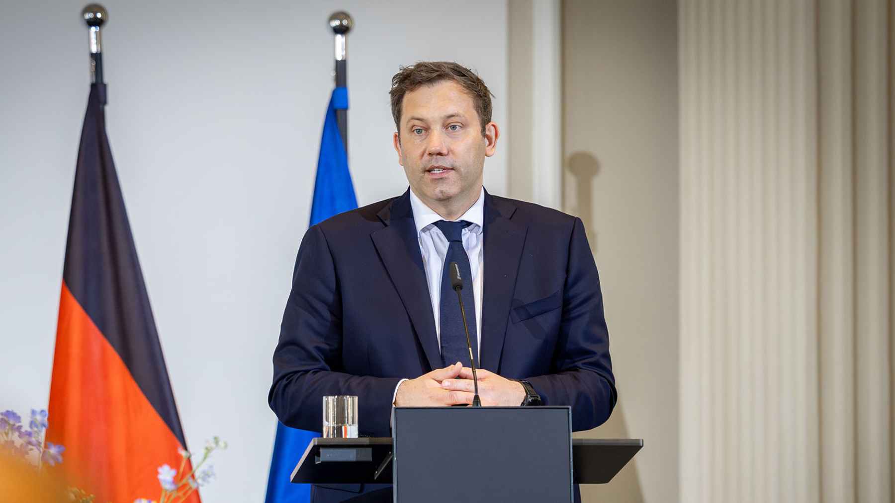 German finance minister Lars Klingbeil speaks at a podium as Germany responds to Trump’s Greenland threats and cites international law.