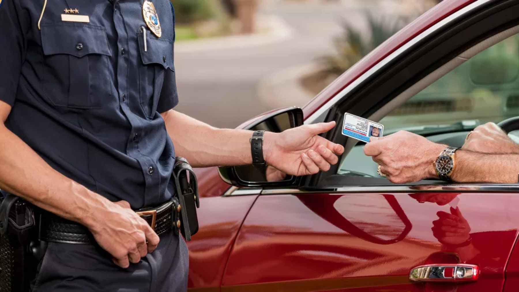Police officer checks a driver’s license during a traffic stop, as states move from magnetic stripes to barcodes and digital security.