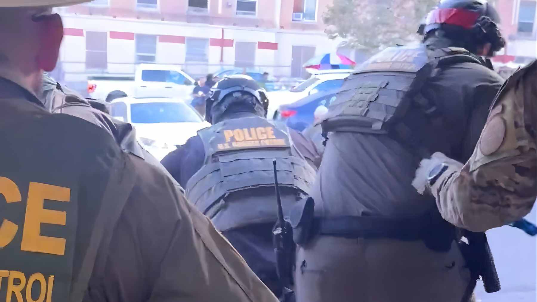 Federal immigration and police agents enter a commercial building during an enforcement operation in Downey, California.