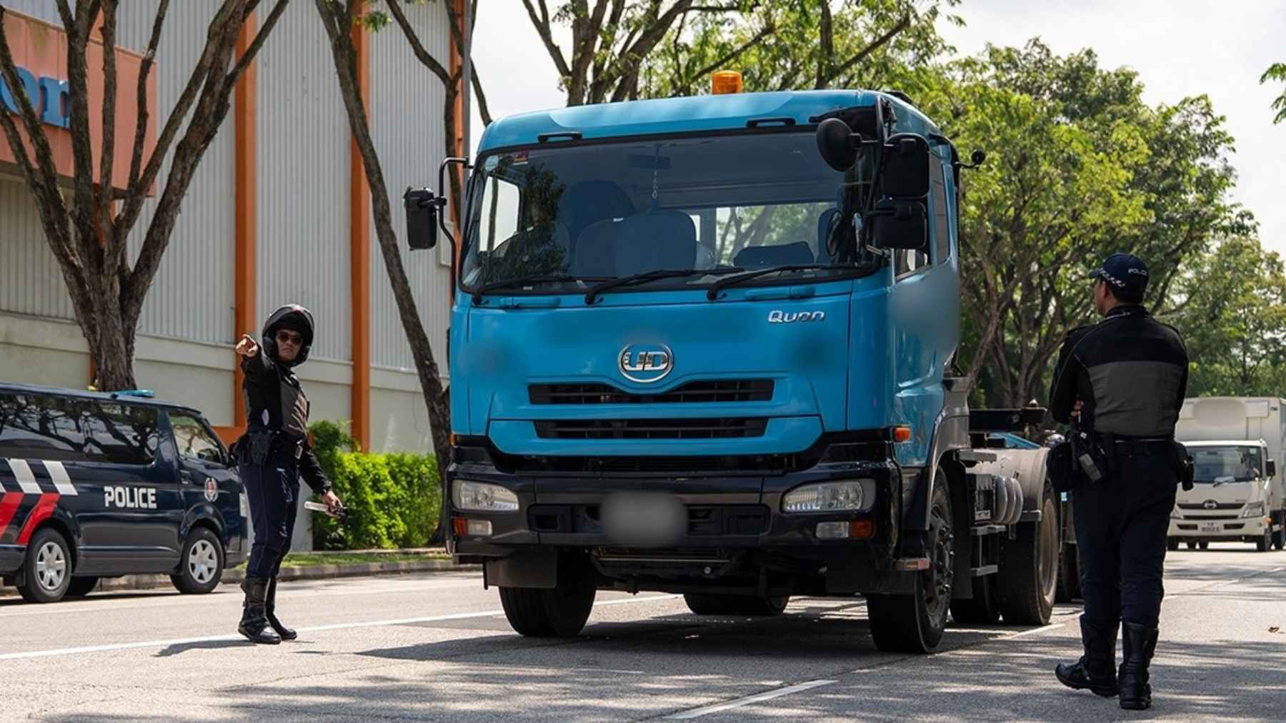 Singapore Traffic Police stop a lorry during a roadside check as authorities enforce the 60 km/h electronic speed-limiter rule.