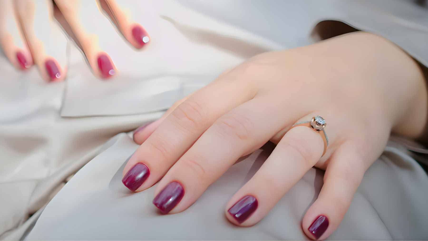 Close-up of a manicured hand with square-shaped nails, showing the clean, straight edge of the nail tip.