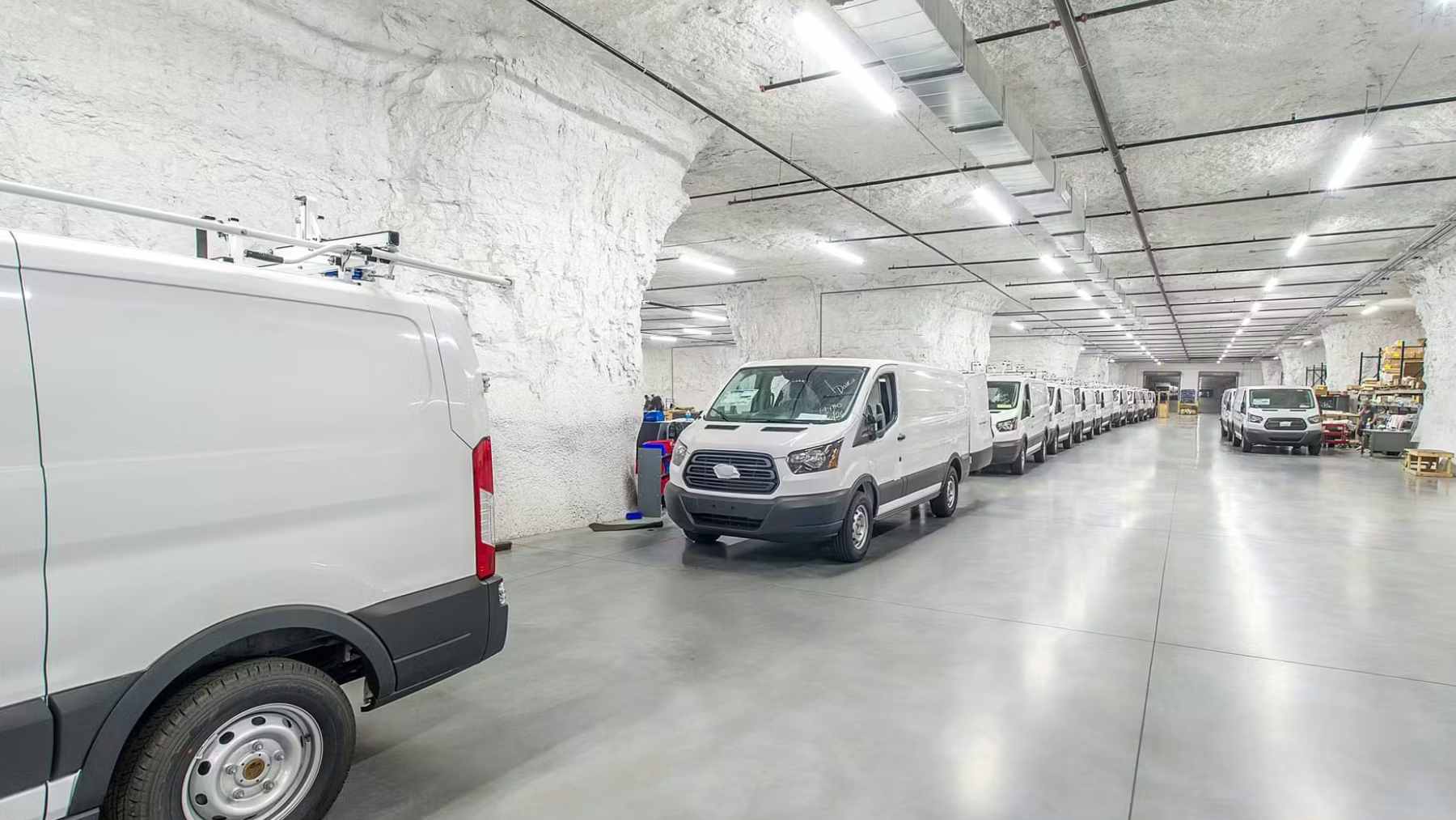 Redovi bijelih dostavnih kombija parkiranih unutar podzemnog vapnenca SubTropolisa u Kansas Cityju.
