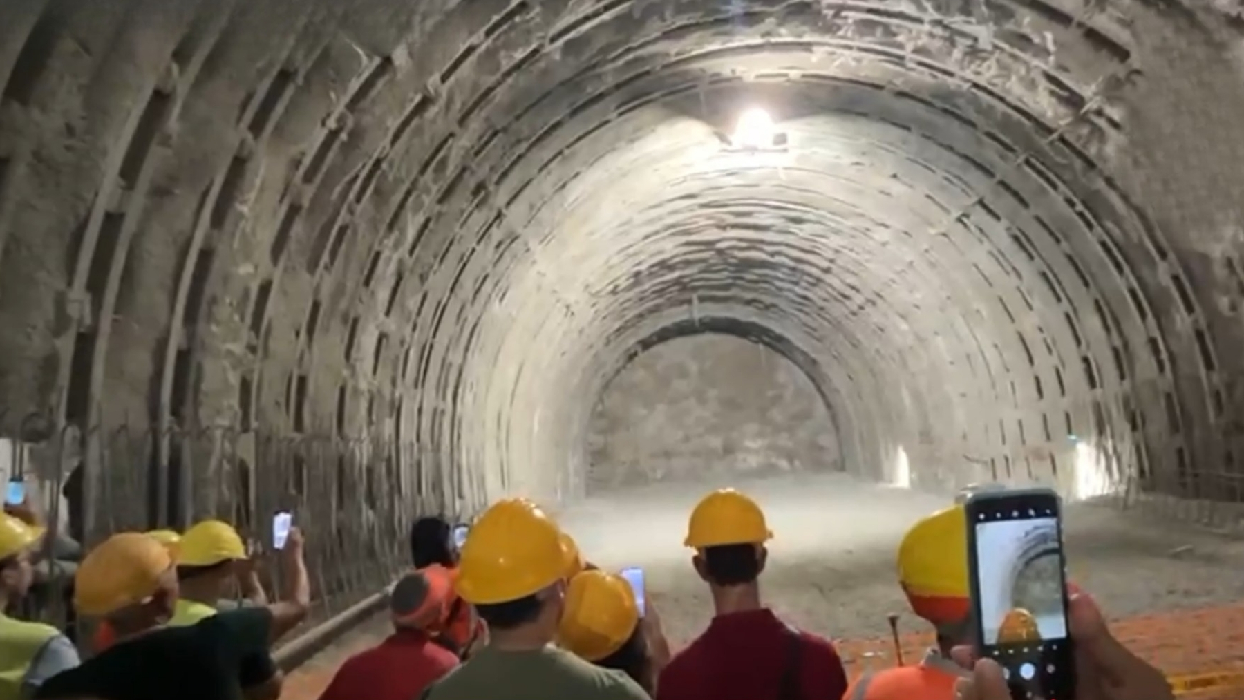Construction crews in hard hats stand inside a large, concrete lined tunnel, a visual of Europe’s hidden underground routes.