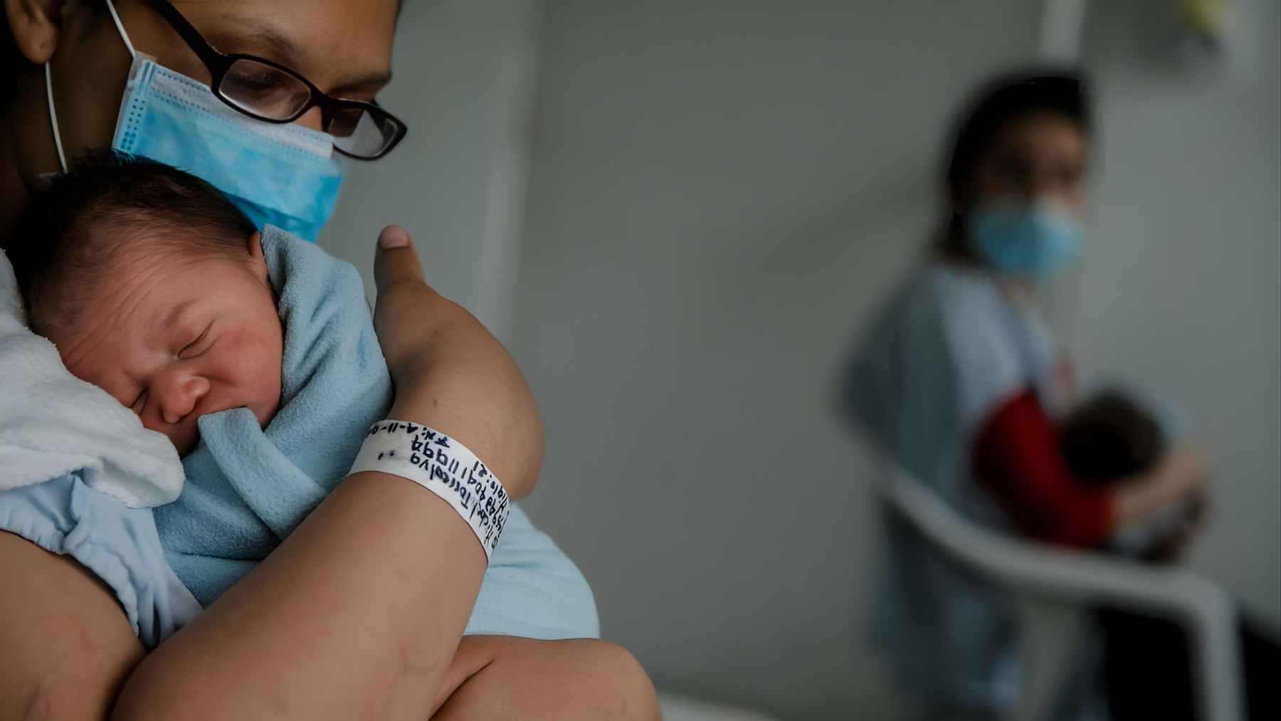 A newborn baby is held in a hospital in Bogotá, Colombia, shortly after birth.