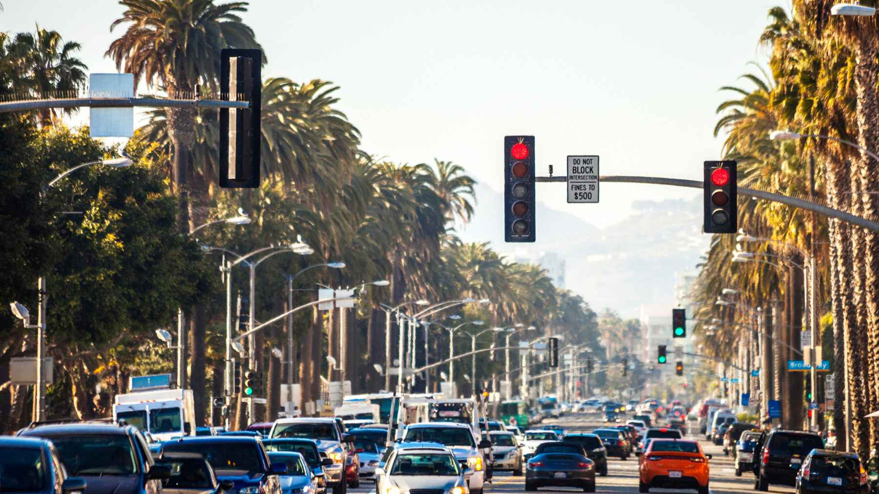 Traffic backs up at a busy California intersection under red lights, where automated cameras can issue citations for red-light running.