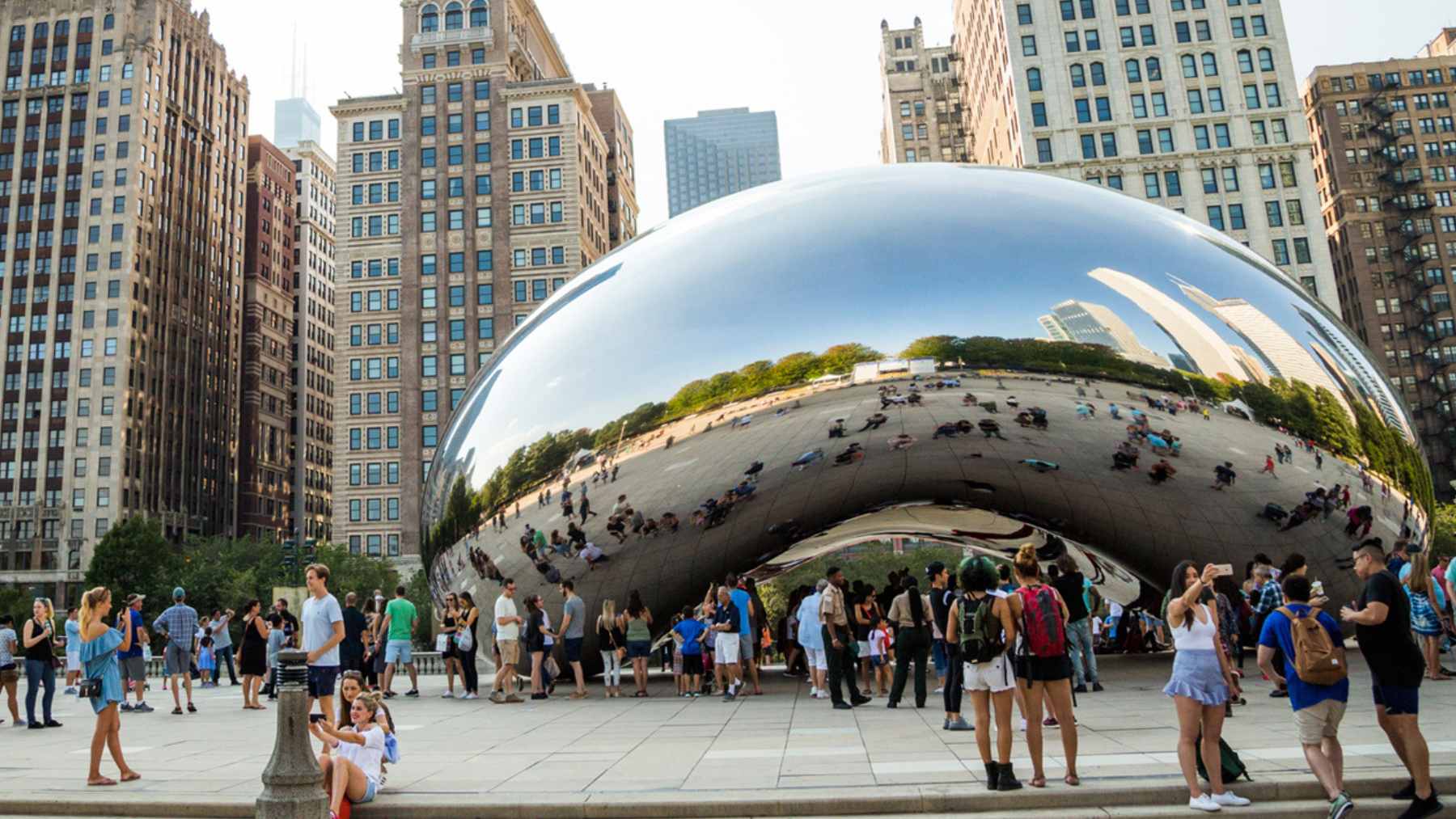 Crowds gather around Cloud Gate in Millennium Park as visitor fees and hotel taxes rise ahead of 2026.