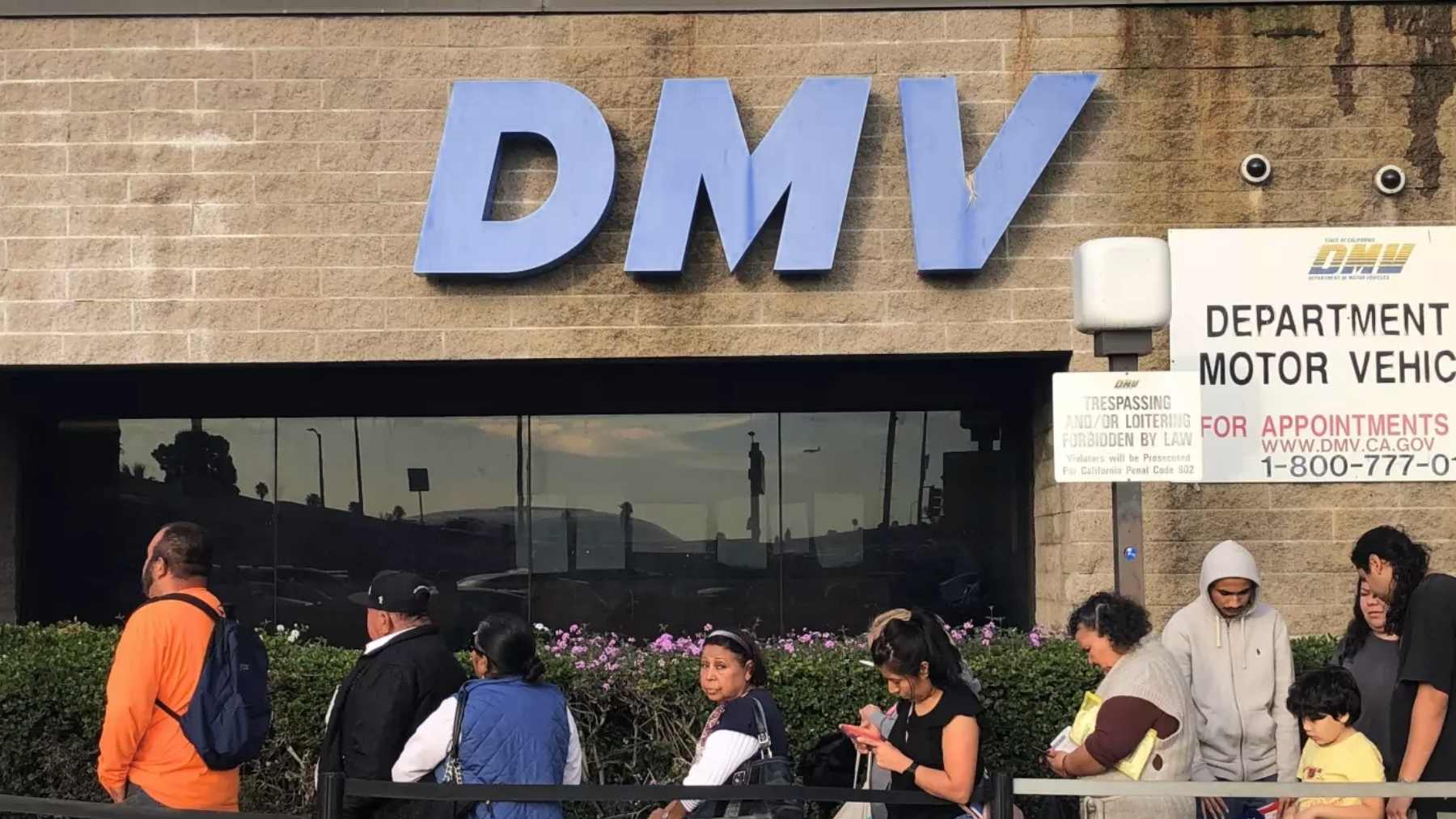 People wait in line outside a California Department of Motor Vehicles office as some REAL ID holders are told to renew due to an error.