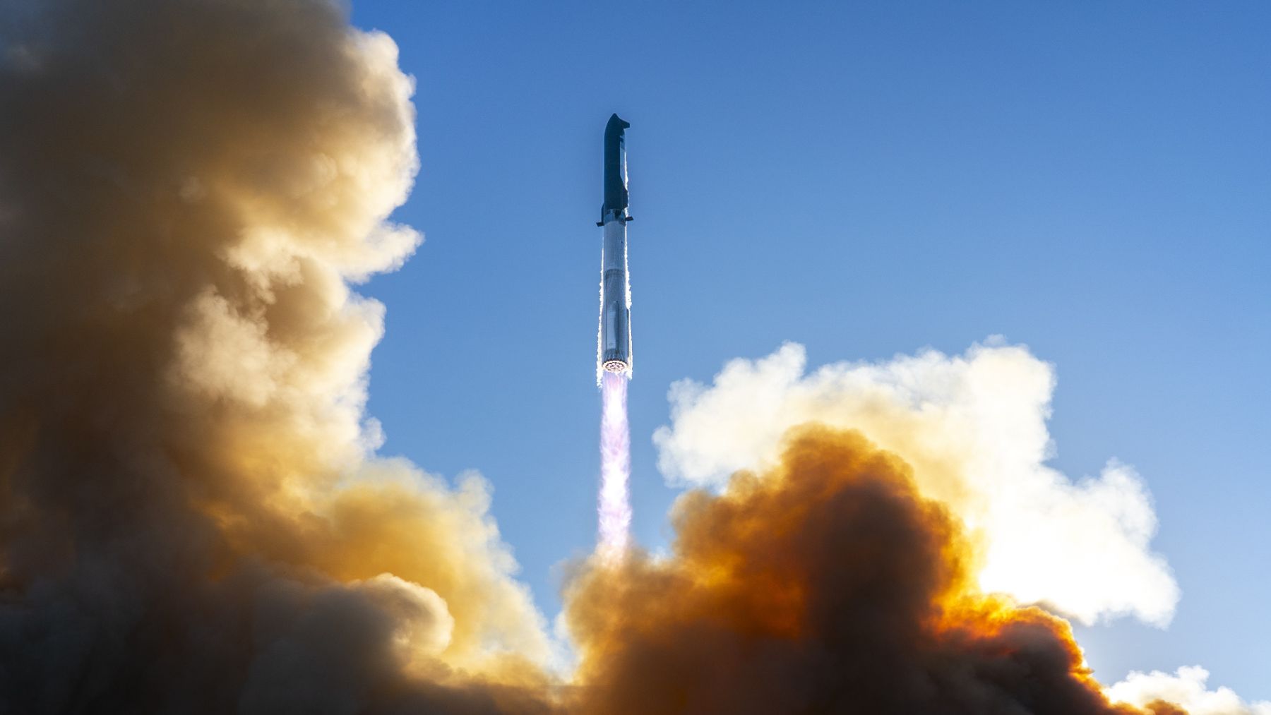 A rocket launches into a blue sky through thick smoke, illustrating the push toward space-based computing and orbital infrastructure.