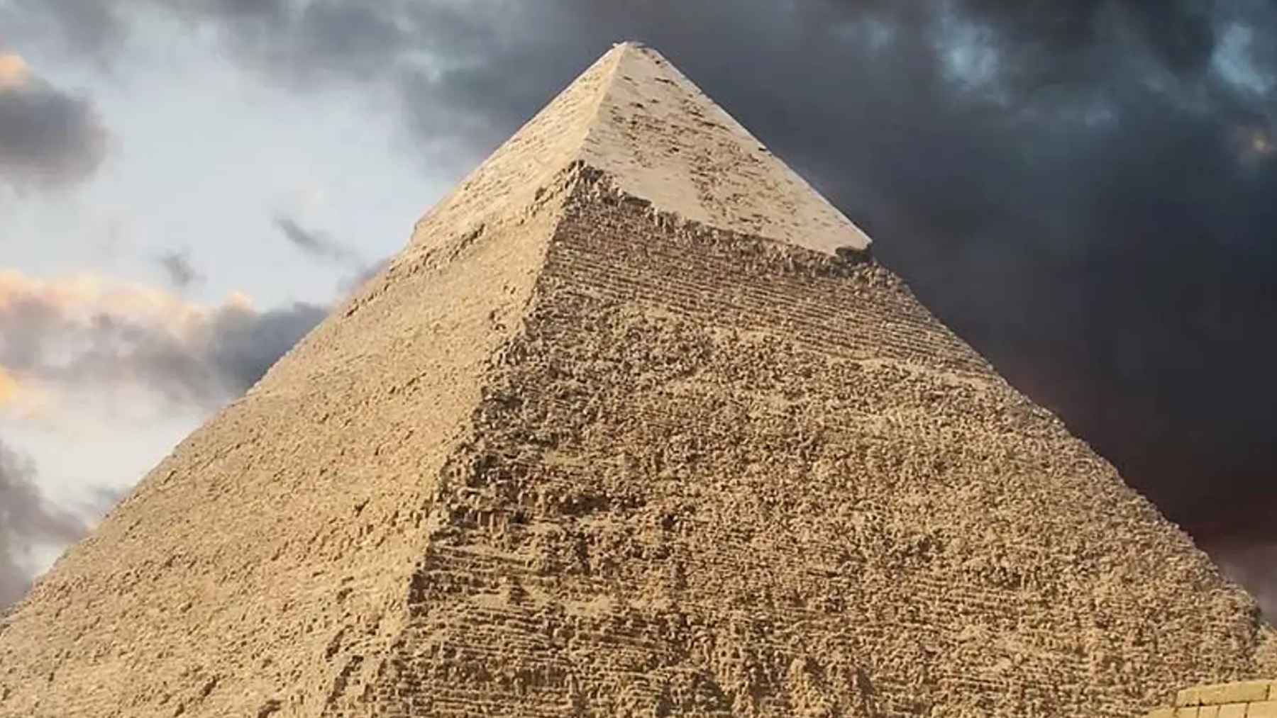 Great Pyramid of Giza under dramatic clouds, as a controversial erosion study suggests it may be far older than the Fourth Dynasty