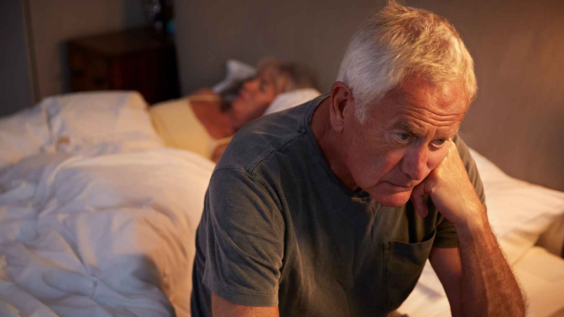 Older adult sleeping in bed at night, illustrating how sleep duration affects inflammation and health in later life