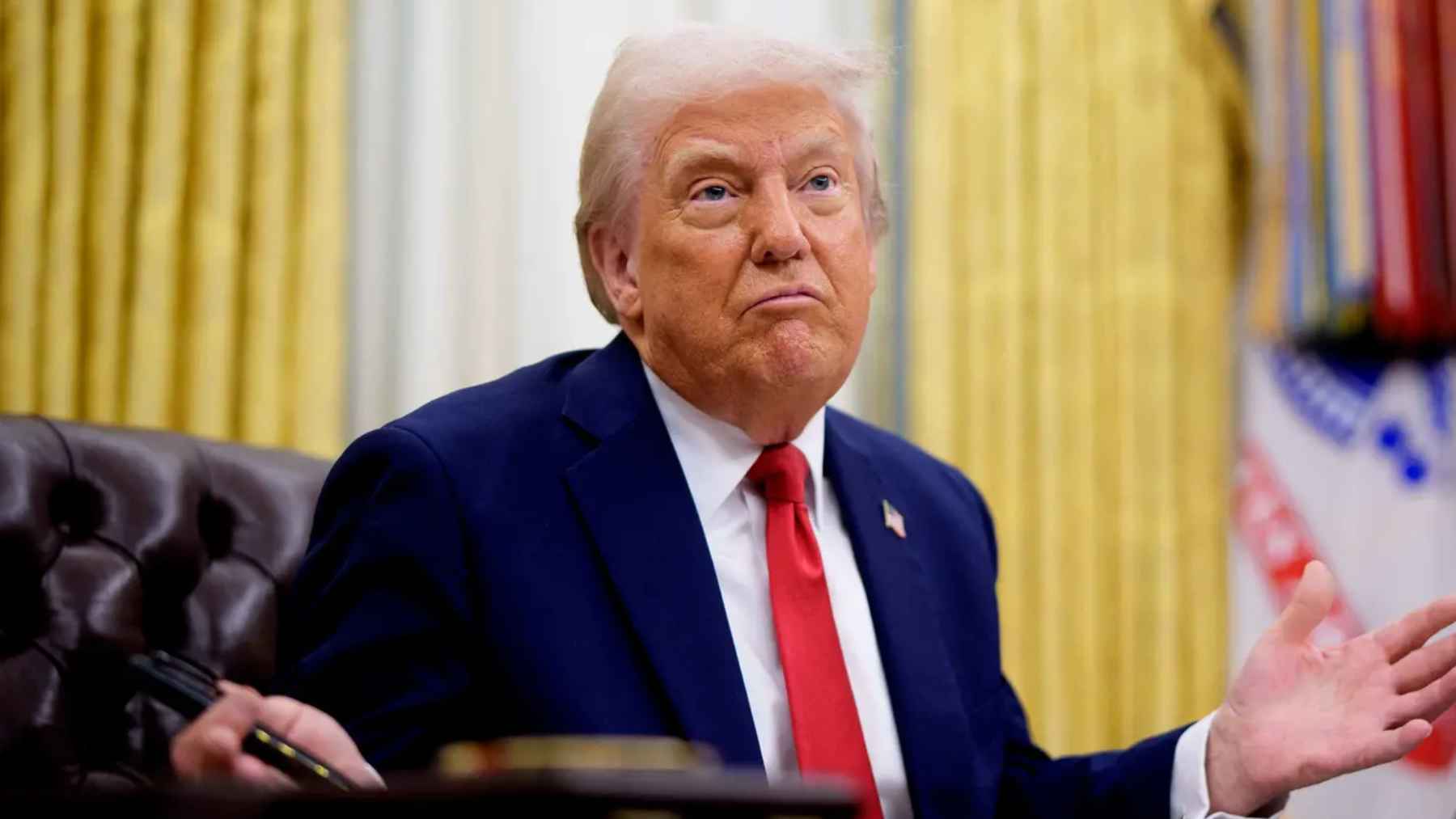 President Donald Trump gestures in the Oval Office amid questions about $2,000 tariff dividend checks