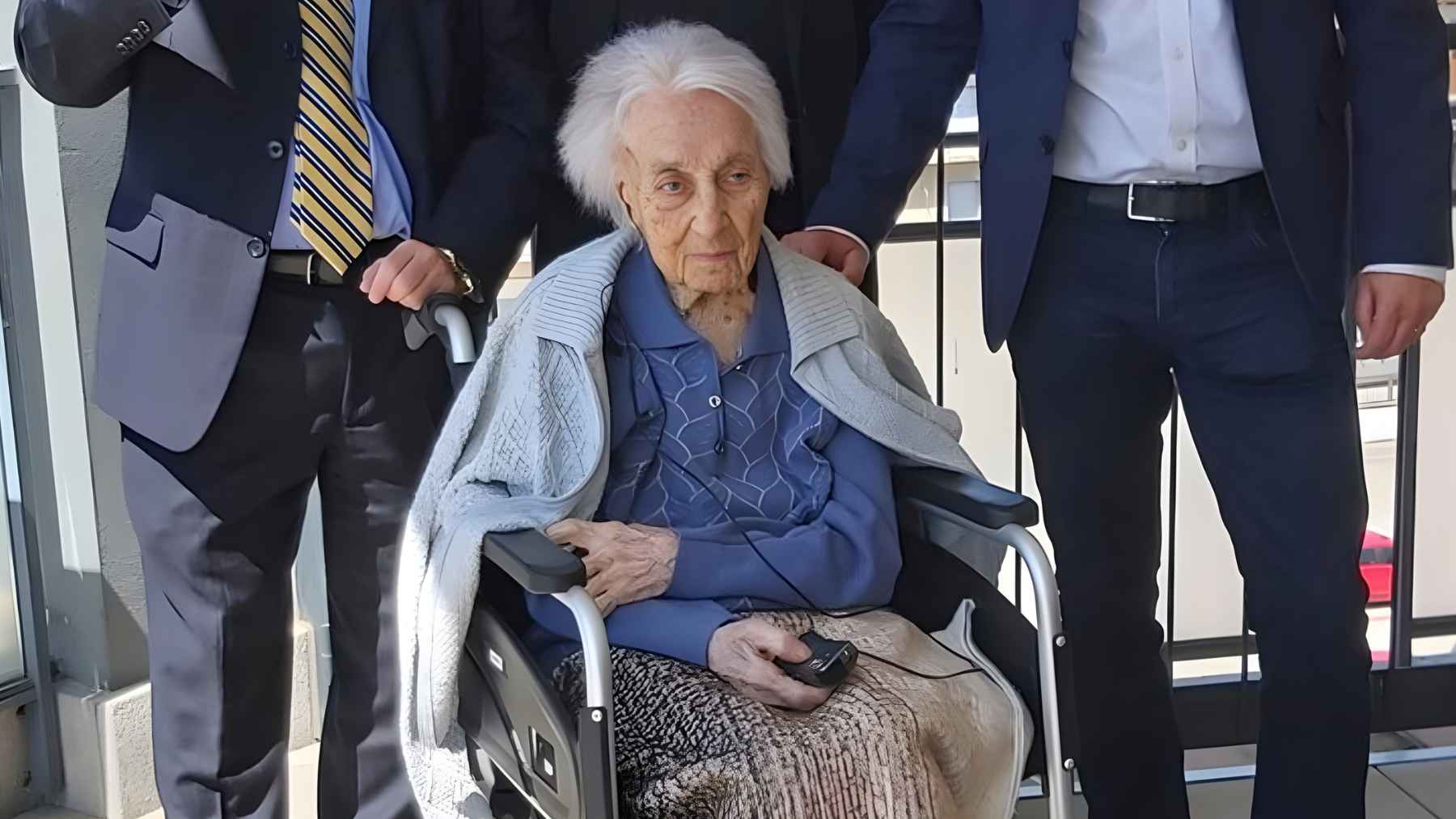 Elderly woman in a wheelchair surrounded by relatives in a photo tied to research on longevity and healthy aging