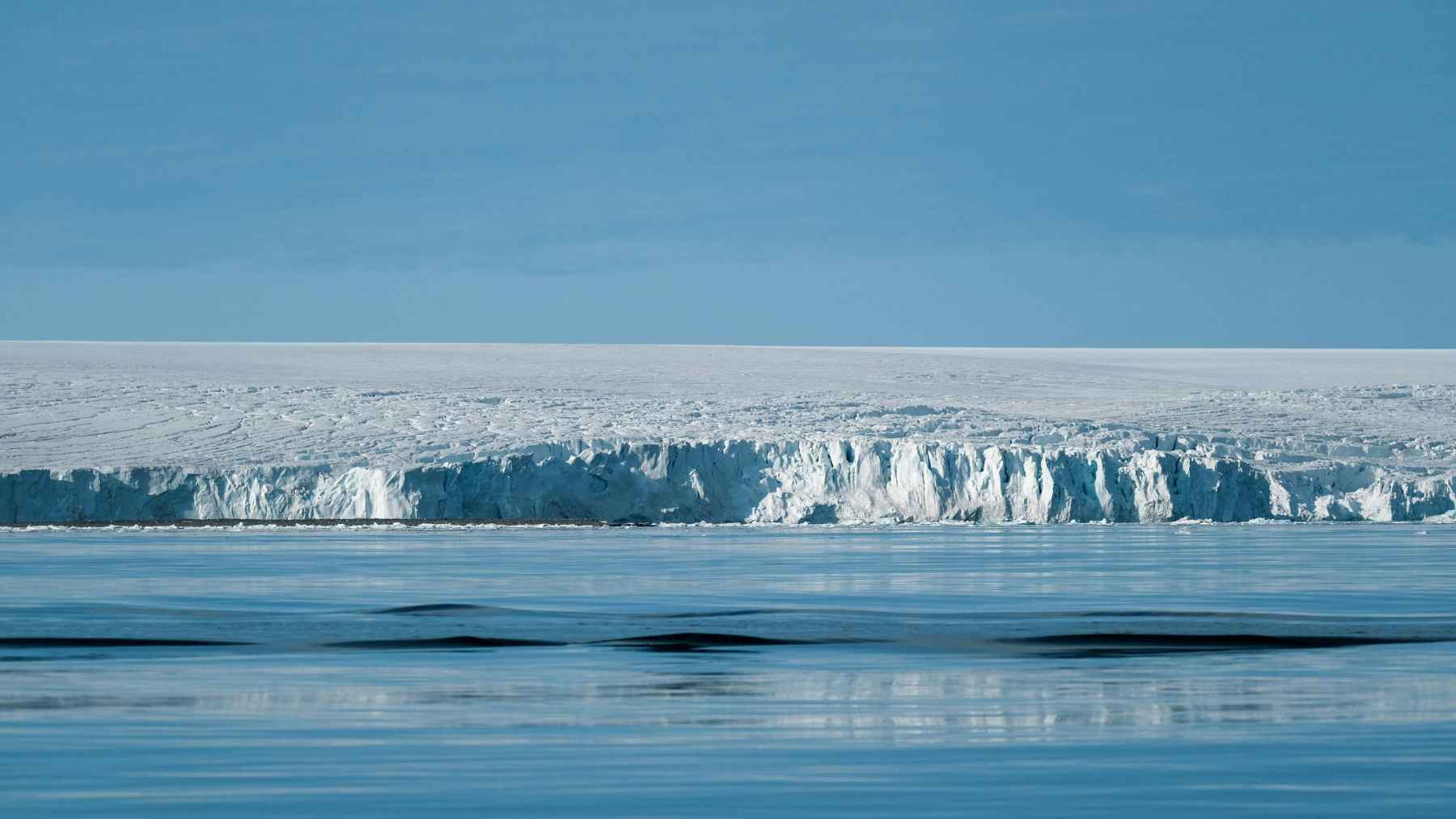 Antarctic ice shelf and calm polar waters, illustrating research on how deep seafloor earthquakes may influence ocean life.