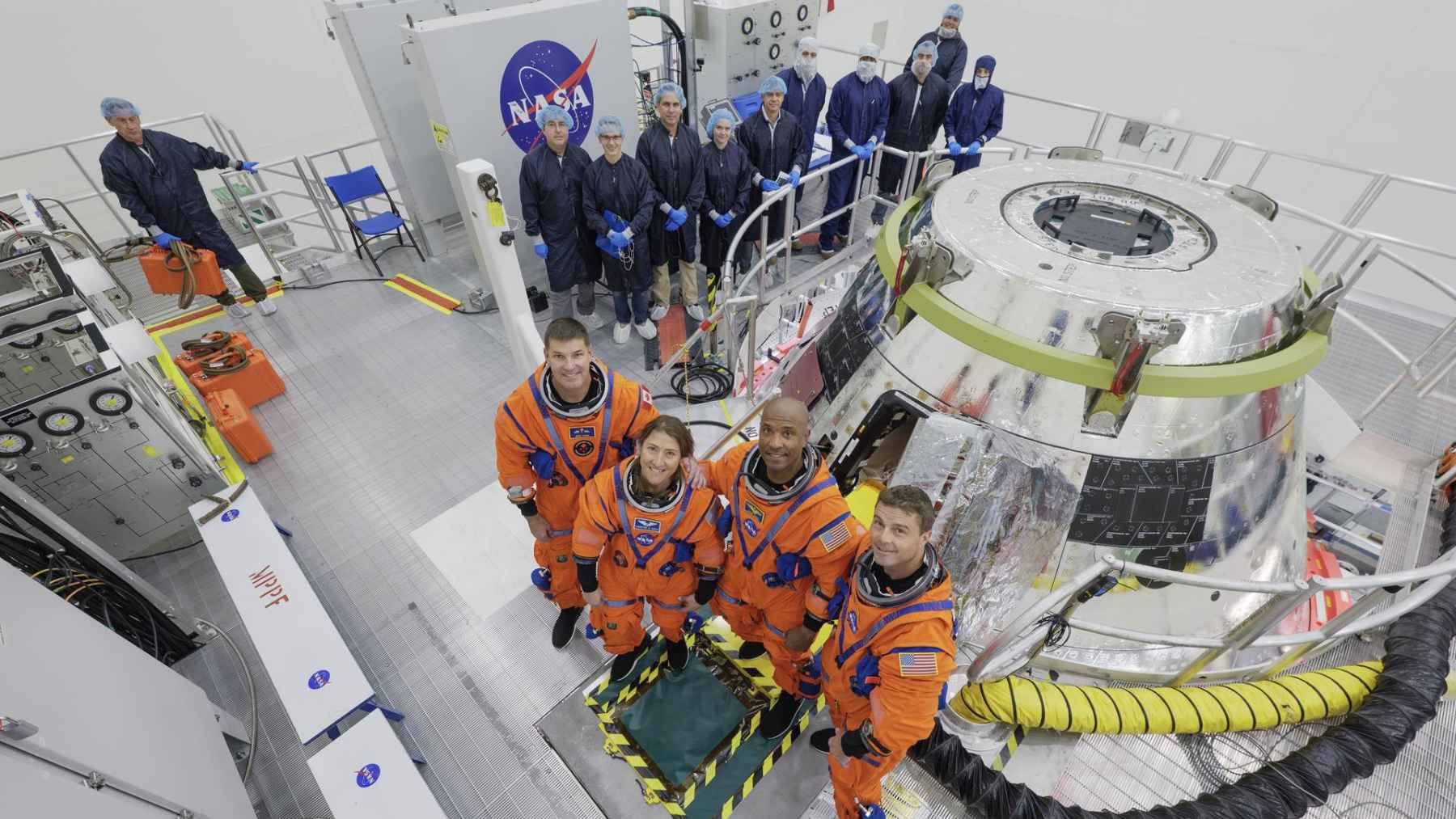 NASA Artemis II astronauts standing beside the Orion spacecraft during mission preparations for the crewed flight around the Moon