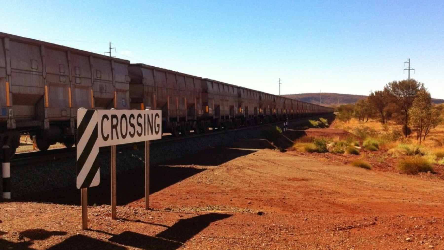 A vast open-pit iron ore mine in Western Australia's Hamersley Province, showcasing the rich red hematite deposits.