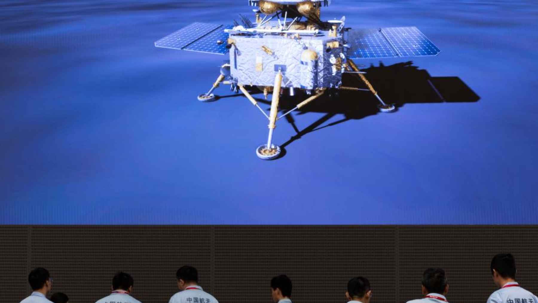 Chinese space engineers watch a large screen showing a lunar lander, linked to the Chang’e mission that returned Moon samples