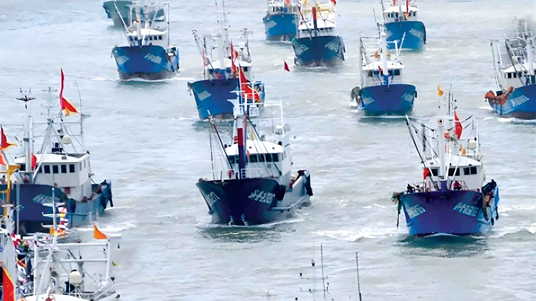 Large fleet of Chinese fishing boats moving in formation at sea, illustrating the mass vessel presence linked to the East China Sea barrier.