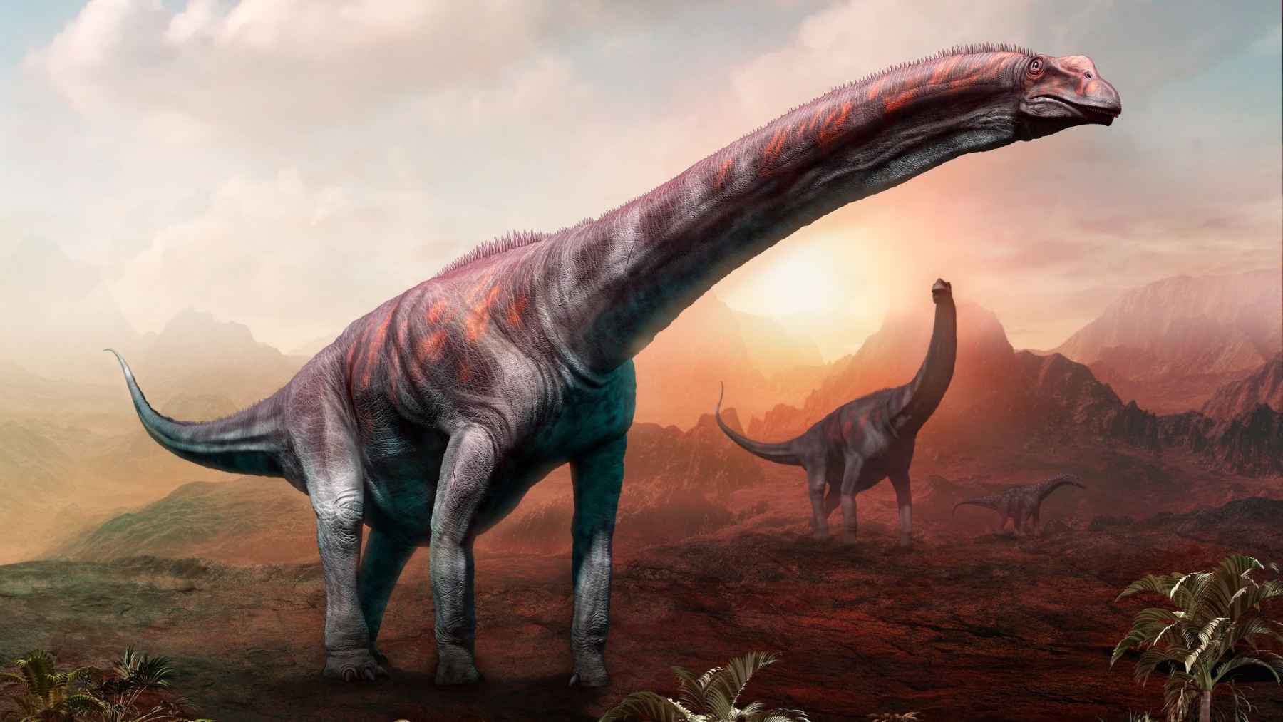 Illustration of giant sauropod dinosaurs in a prehistoric landscape at sunset, representing research on how fast large dinosaurs could move