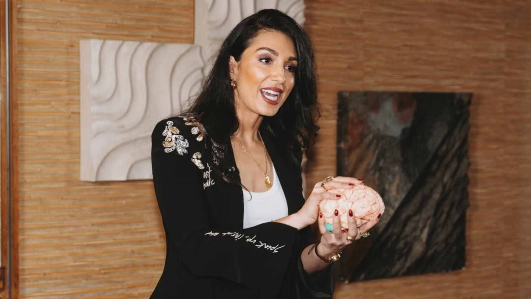 Neuroscientist Louisa Nicola explaining the physiological benefits of frequent movement breaks and squats for brain health and glucose control.