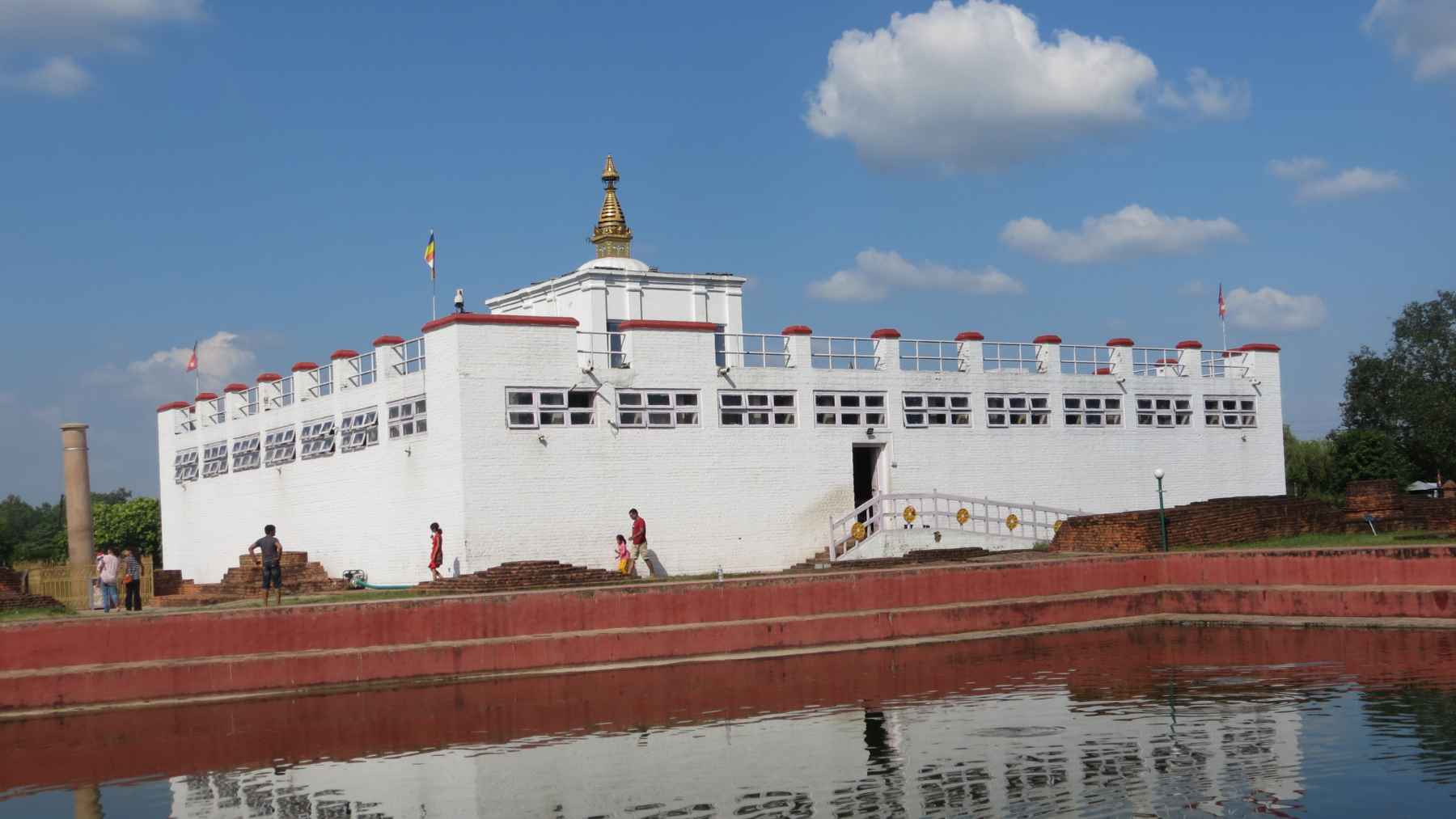 Maya Devi Temple in Lumbini, Nepal, reflected in a pond, illustrating the site traditionally recognized as the birthplace of Buddha.