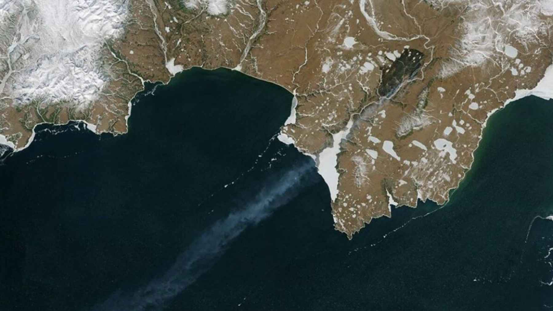 NASA satellite image showing wildfires burning across snowy Arctic terrain near the North Pole