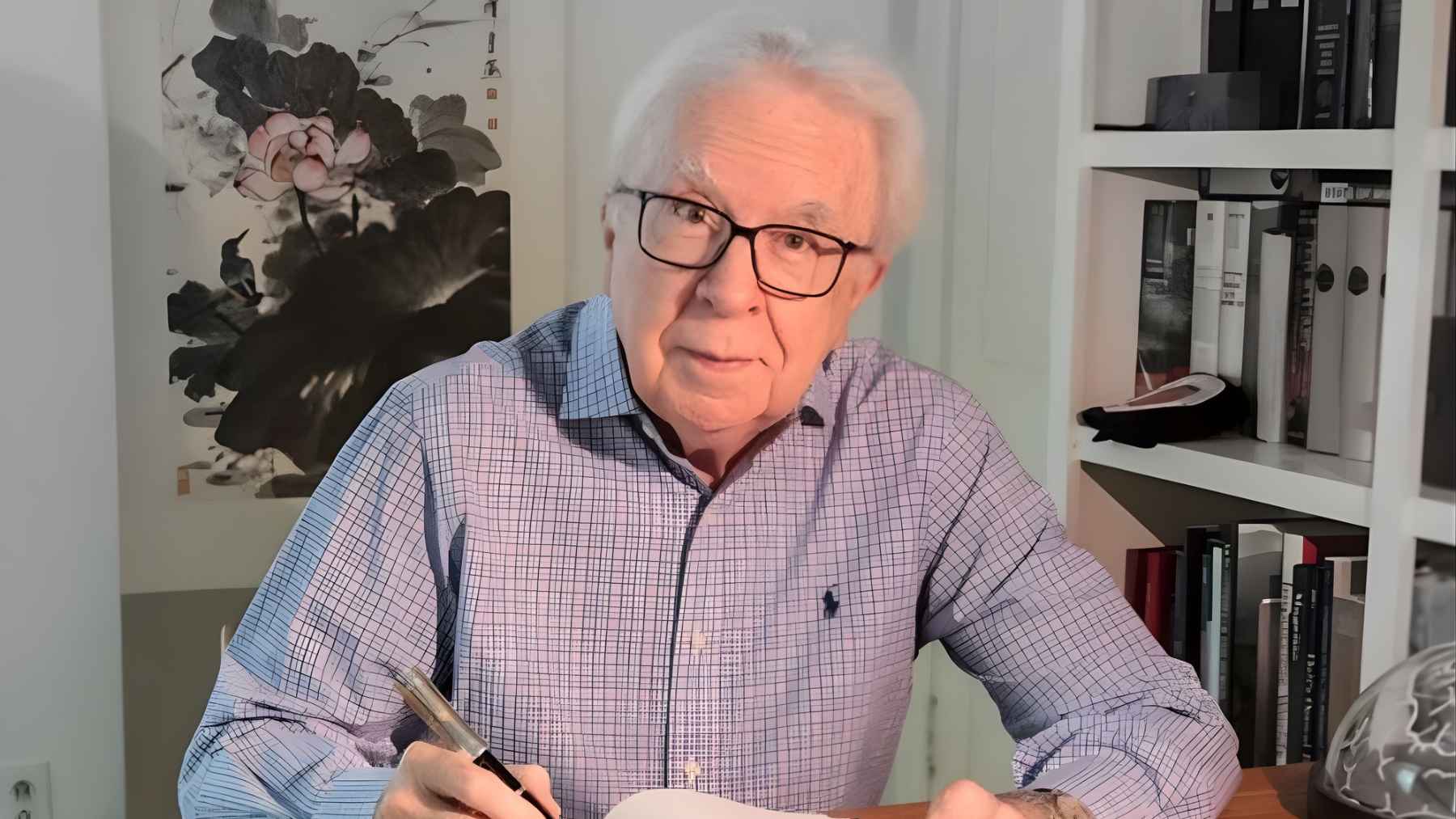 ECOnews 1 Richard Restak seated at a desk writing in a notebook, illustrating the neurologist’s warning about alcohol, memory, and aging after 65