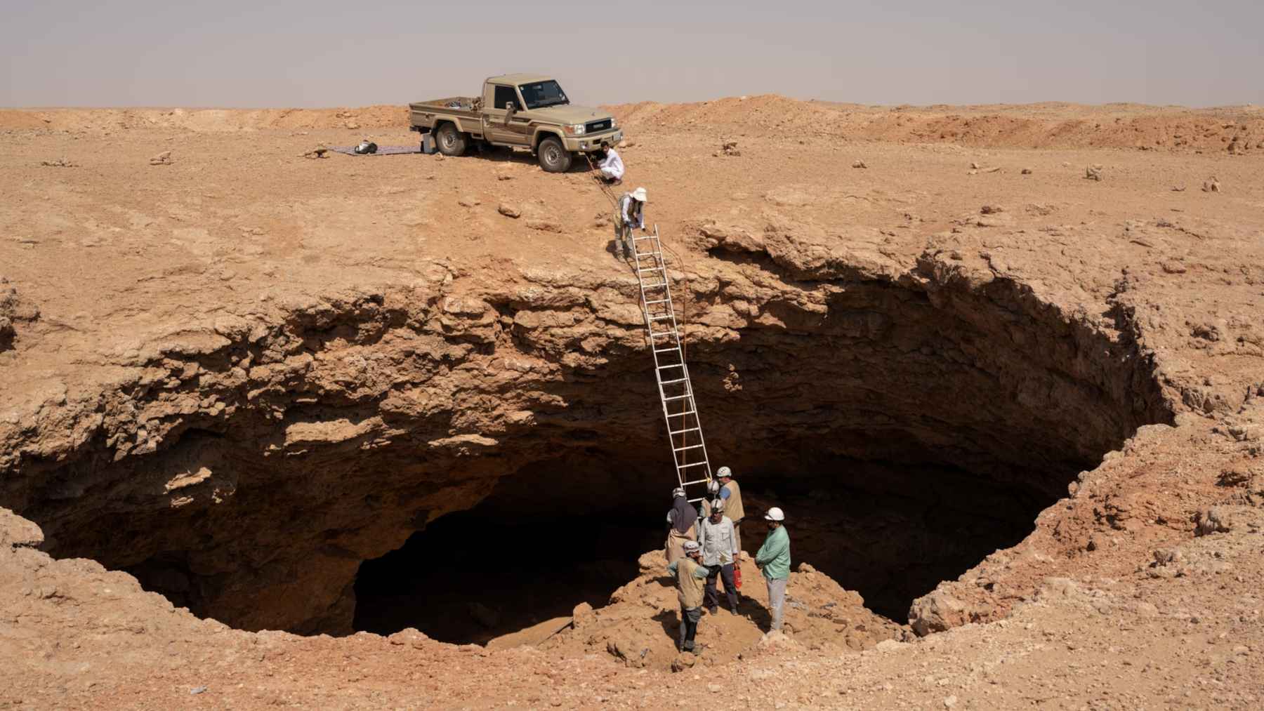 Researchers descending into a desert cave near Arar in northern Saudi Arabia, where naturally mummified cheetah bodies were discovered