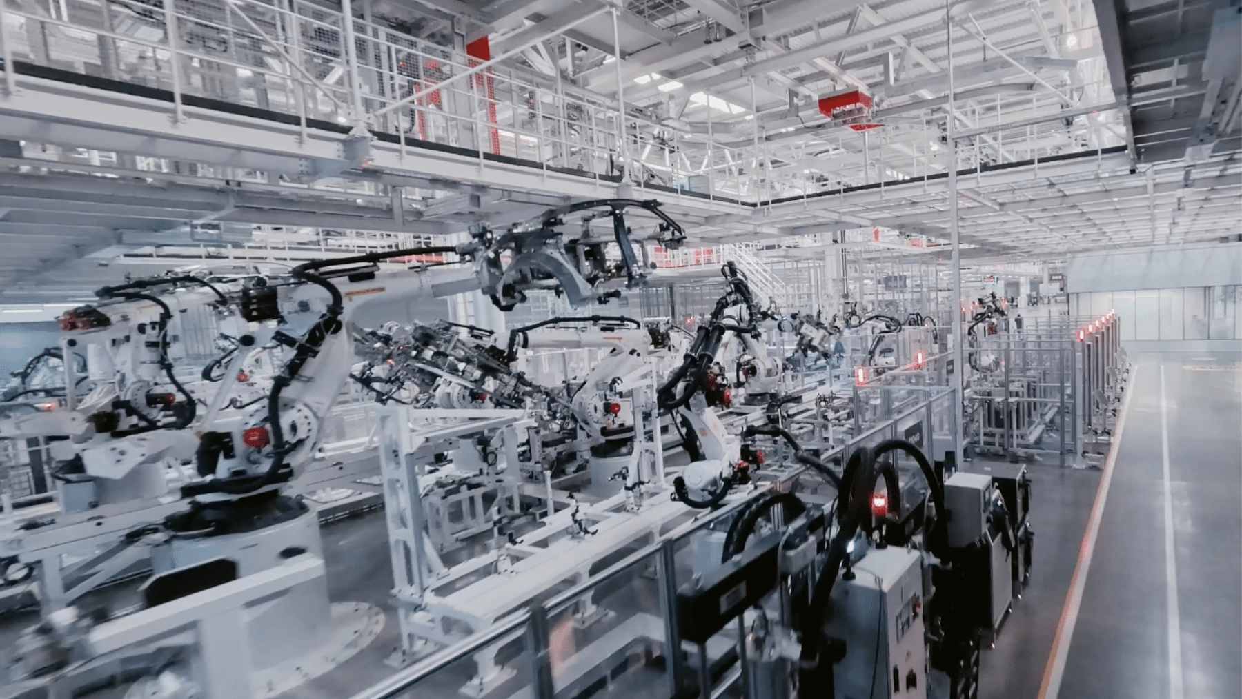 An automated robotic assembly line inside Xiaomi's "lights-out" Smart Factory in Beijing, showing robotic arms assembling flagship smartphones.