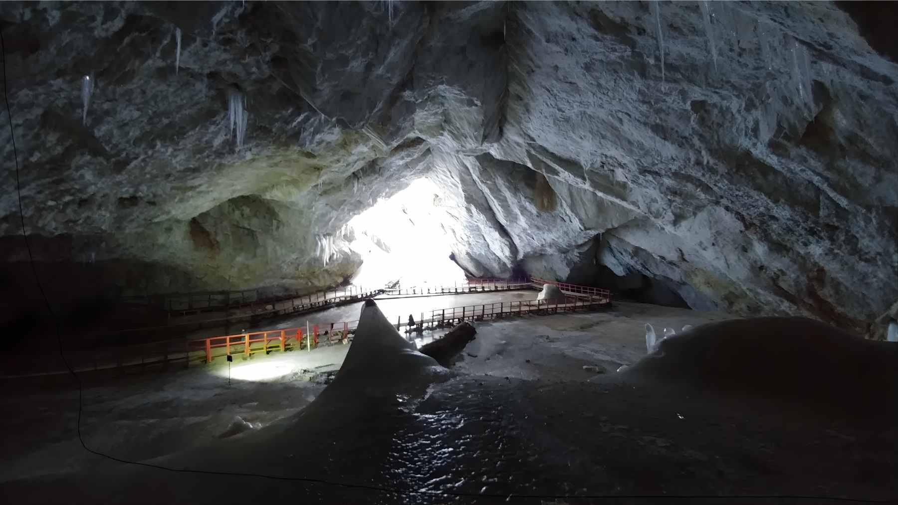 Researchers extracting a vertical ice core sample from the frozen floor of a Romanian cave for microbial analysis.