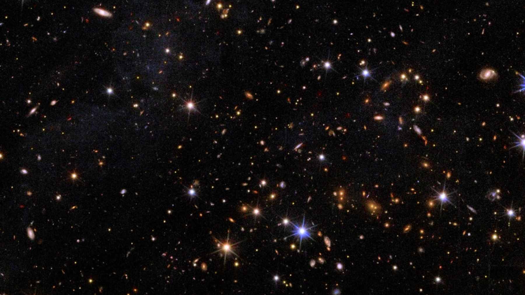 A deep-space composite image from the Hubble and Euclid telescopes showing the Perseus galaxy cluster, with a circle highlighting the faint star clusters of CDG-2.