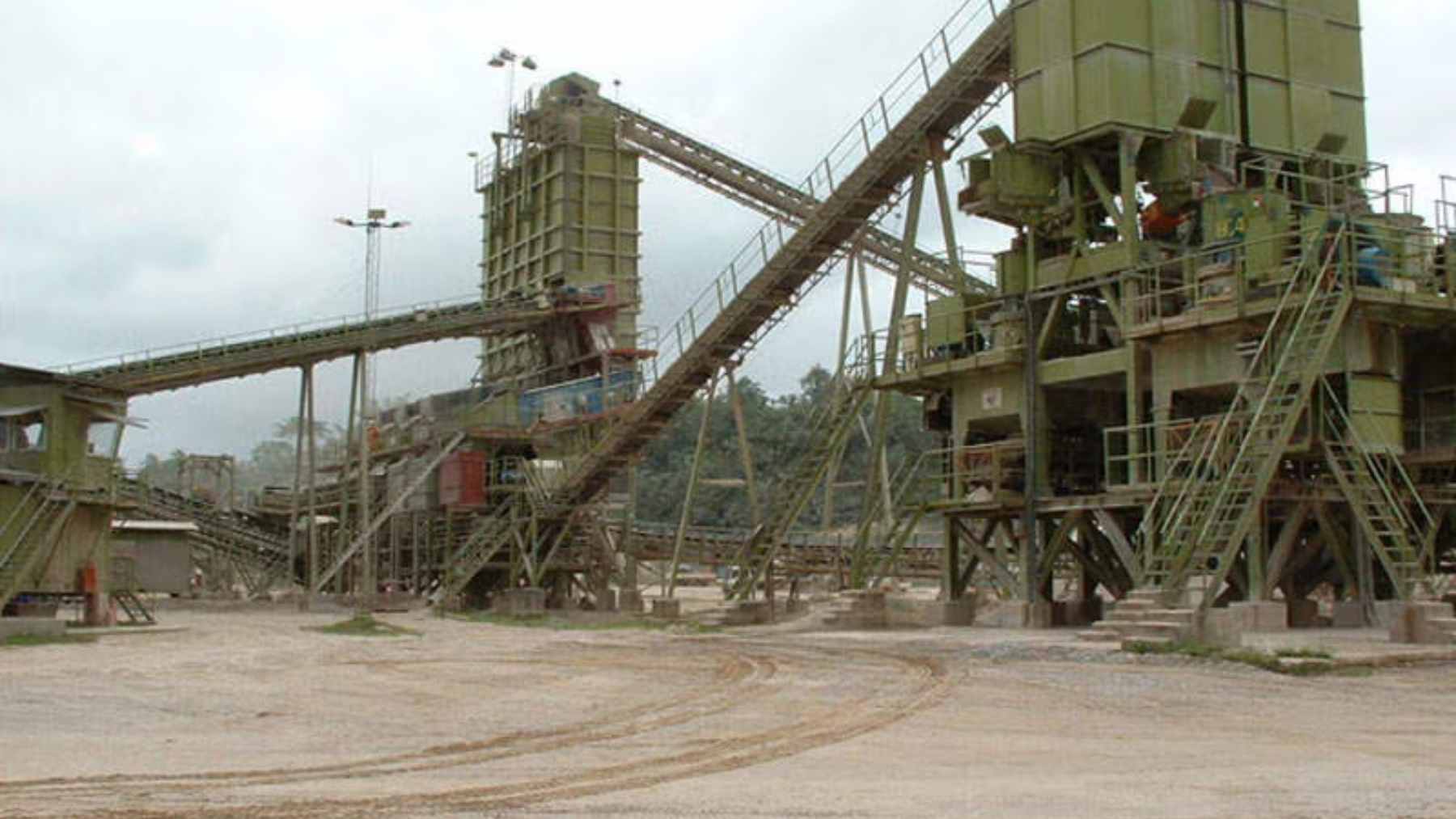 A South African gold miner has become the first major casualty of Ghana’s tighter resource-control push, and the move shows how fast Africa’s mining rules are changing 1 A wide-angle view of the Damang open-pit gold mine in Ghana, showing heavy machinery and terraced excavation levels.