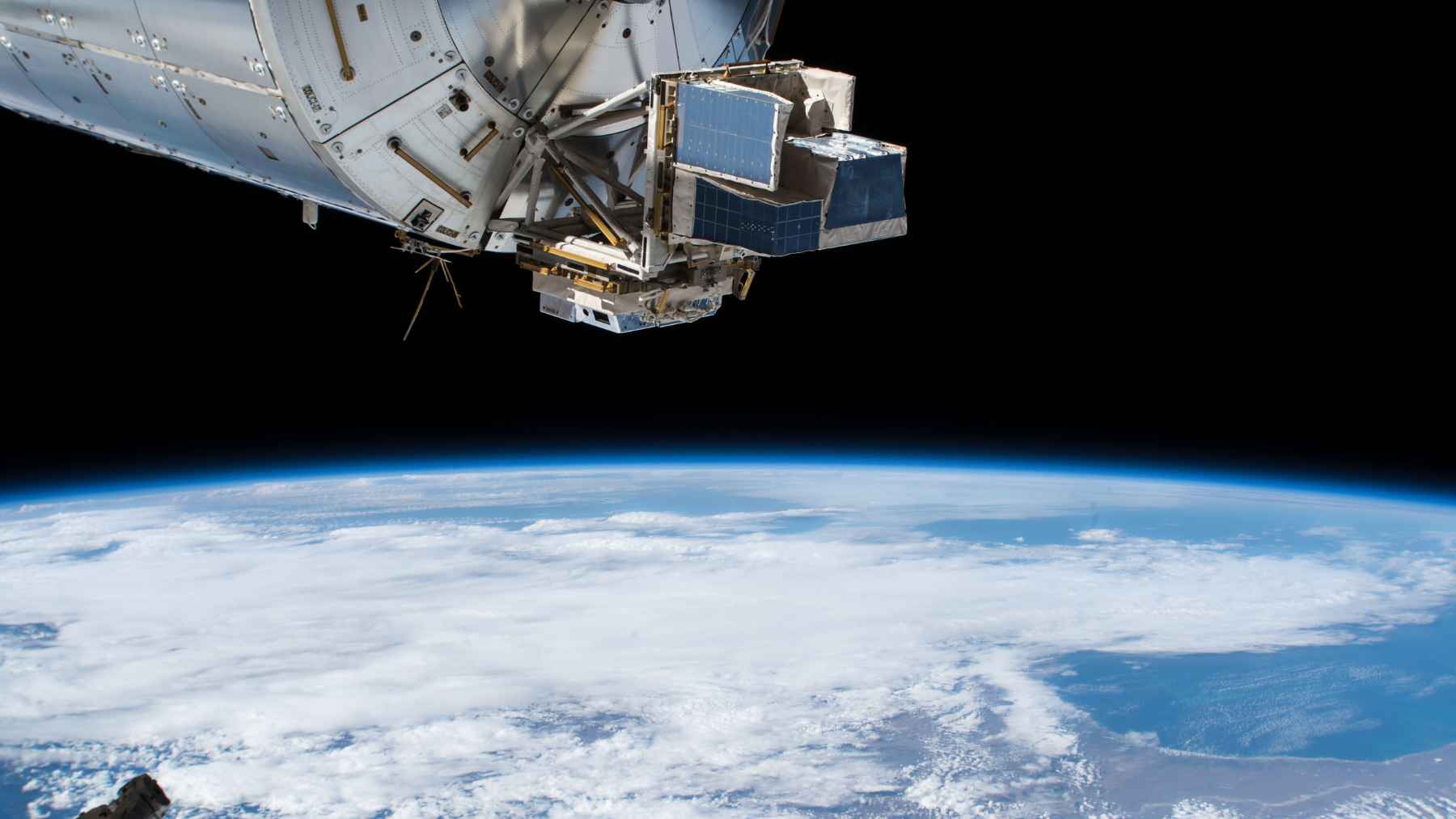 View of upper-atmosphere storm activity from space, showing transient luminous events such as sprites, blue jets, and ELVES above thunderstorms.