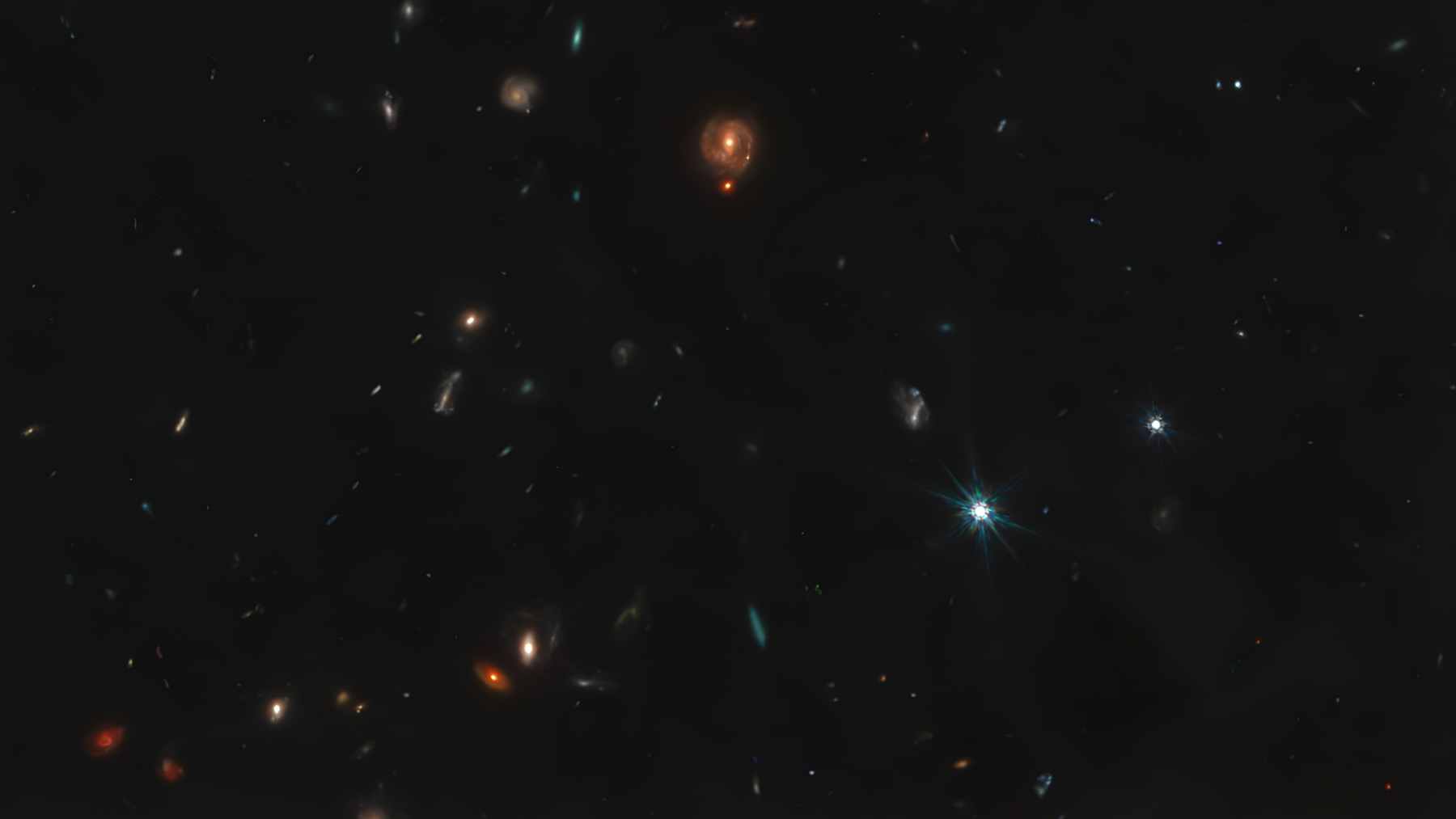 Bright red dots glowing against the dark backdrop of deep space, captured by the James Webb Space Telescope.