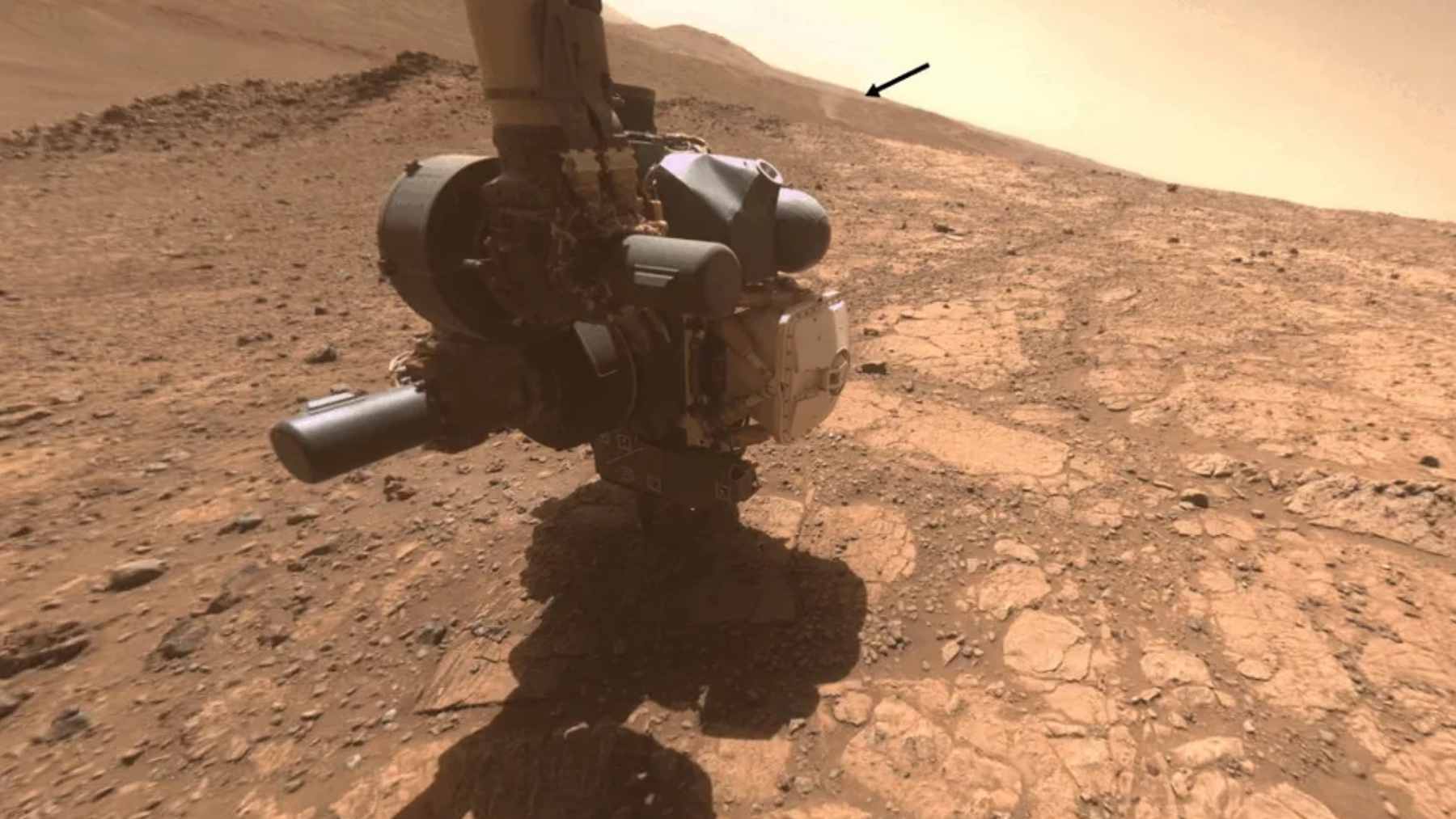 An artist's illustration of a towering Martian dust devil with faint, blue electrical spark discharges flickering within the swirling orange sand.