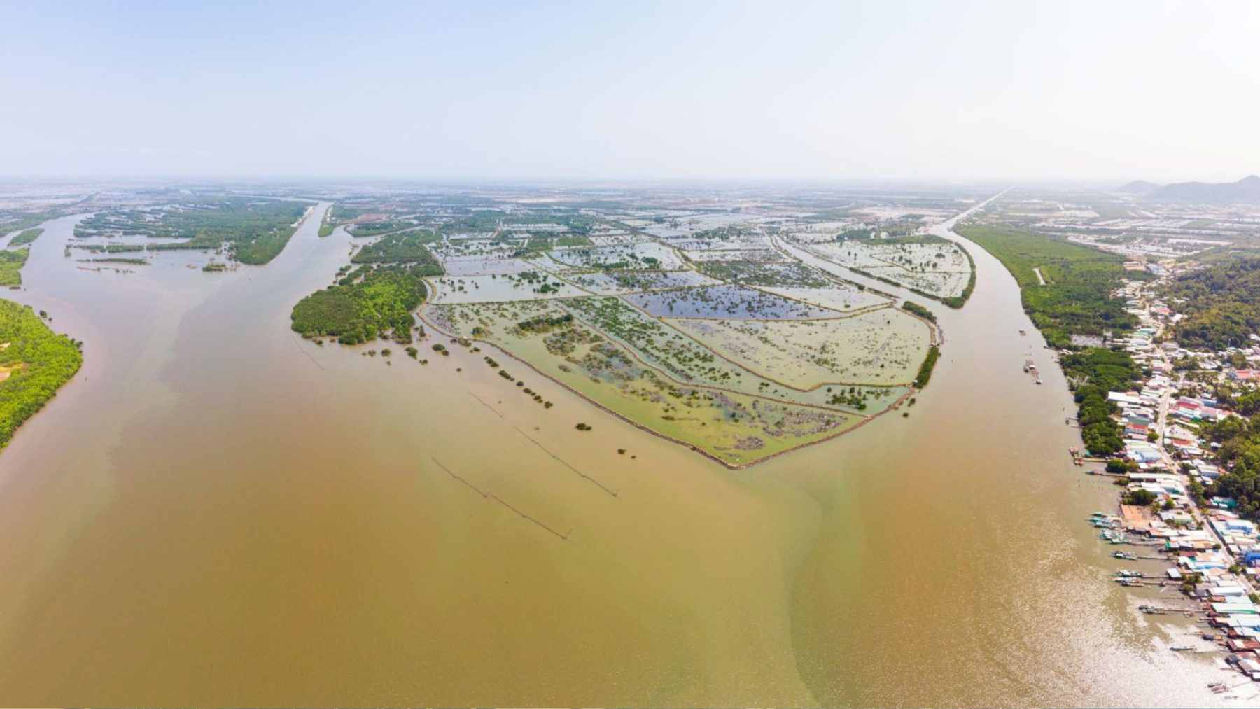An aerial view of a coastal city facing encroaching floodwaters due to rising global sea levels.