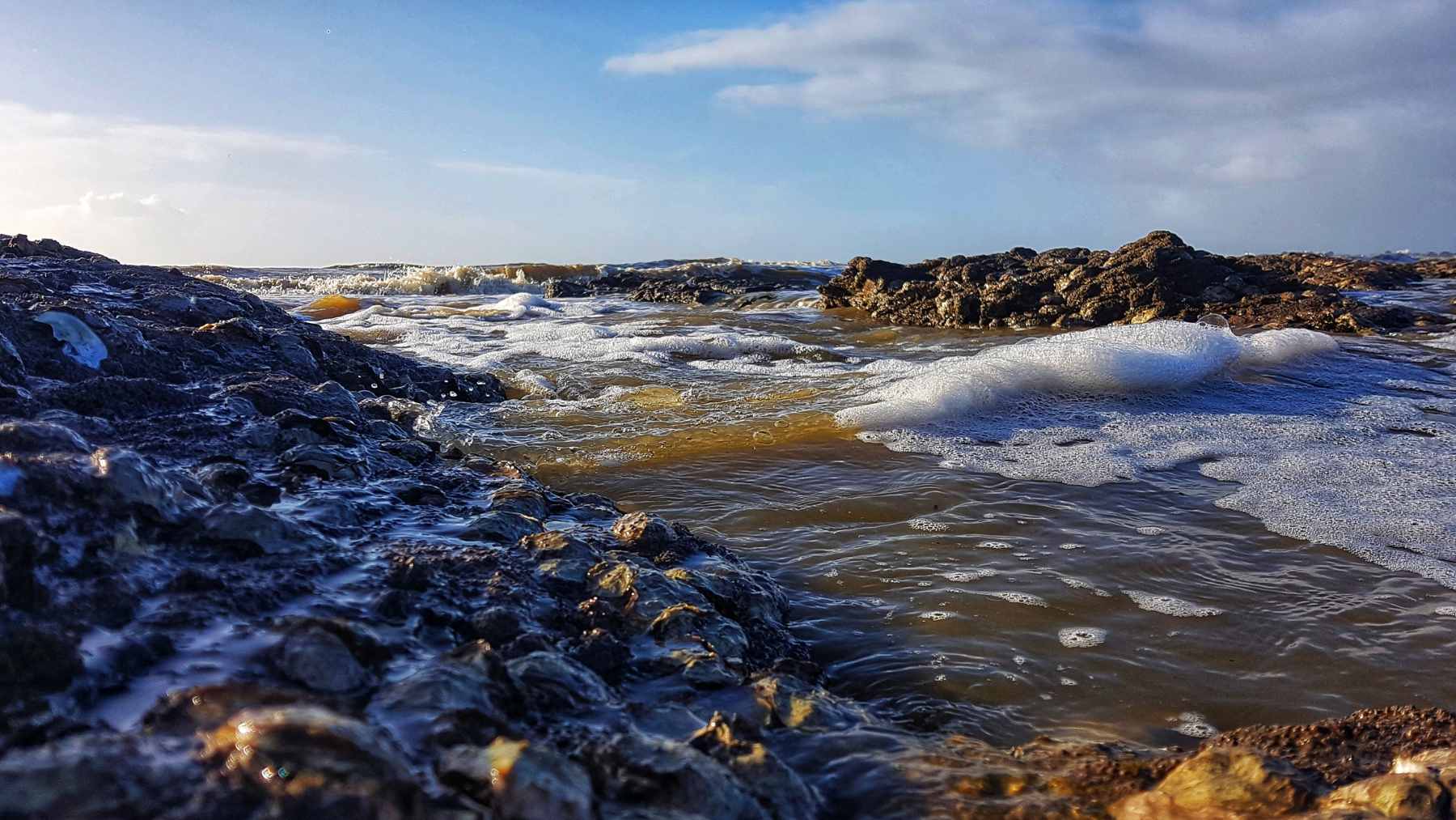 A side-by-side comparison of a standard coastal elevation map and an adjusted map showing significantly higher sea levels and flood risks.