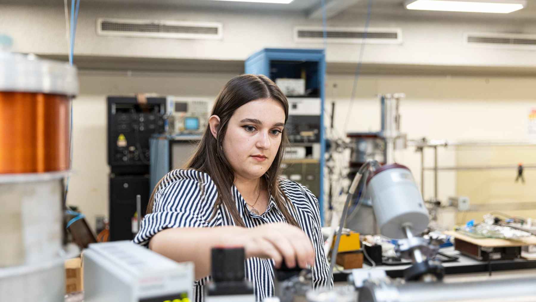 Student working in a laboratory while conducting research to recreate cosmic dust and study the origins of life’s ingredients