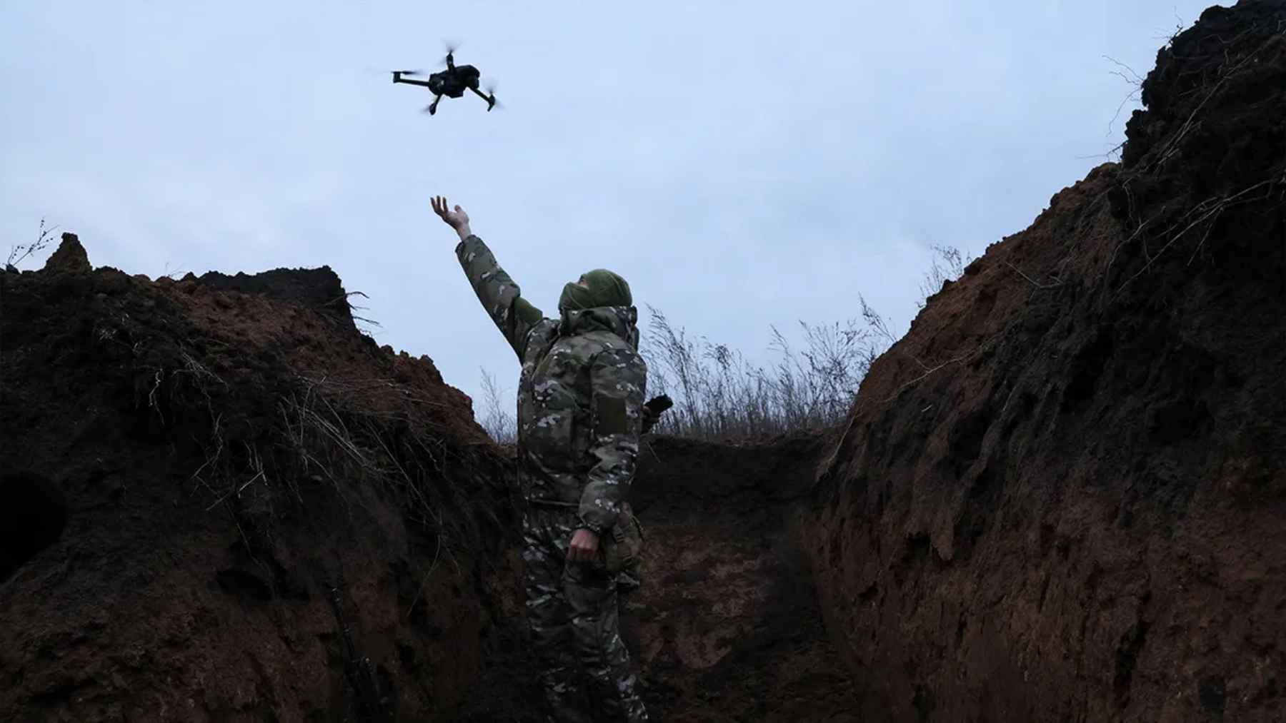 Military drone flying over a battlefield area during the war in Ukraine.