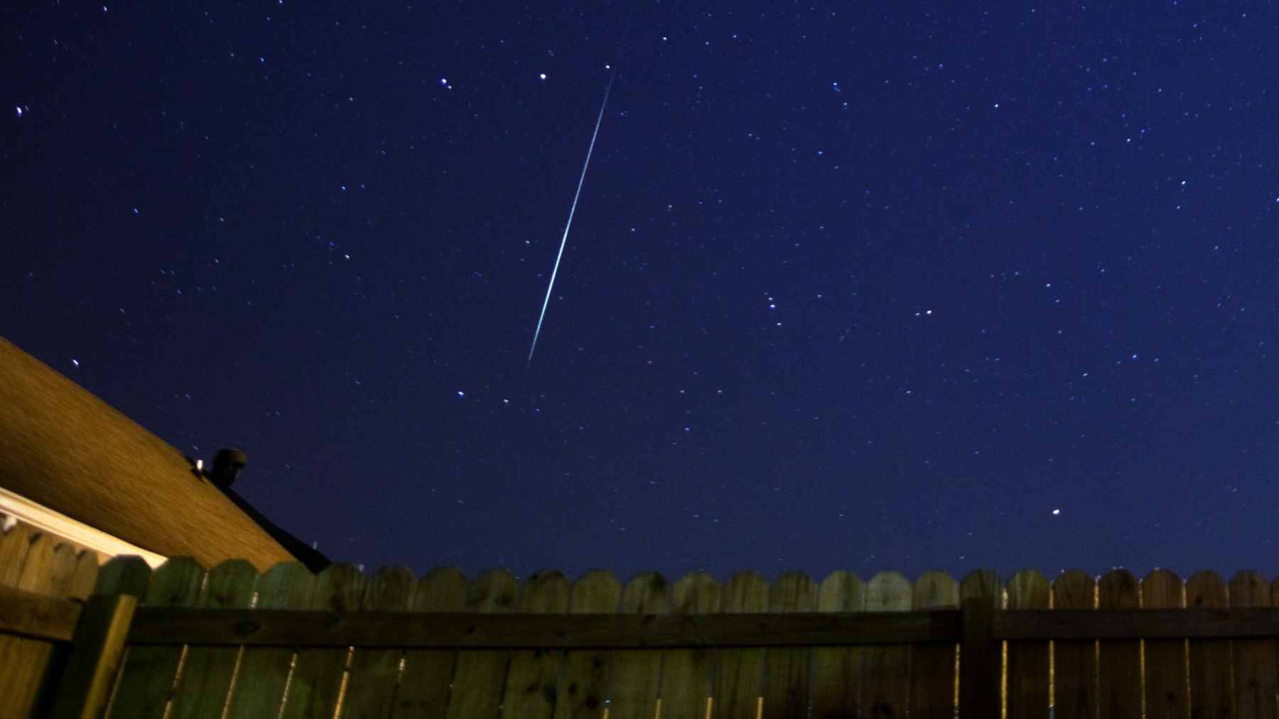 A bright orange streak of light fragmenting as it slowly crosses the dark pre-dawn sky over Victoria, Australia.