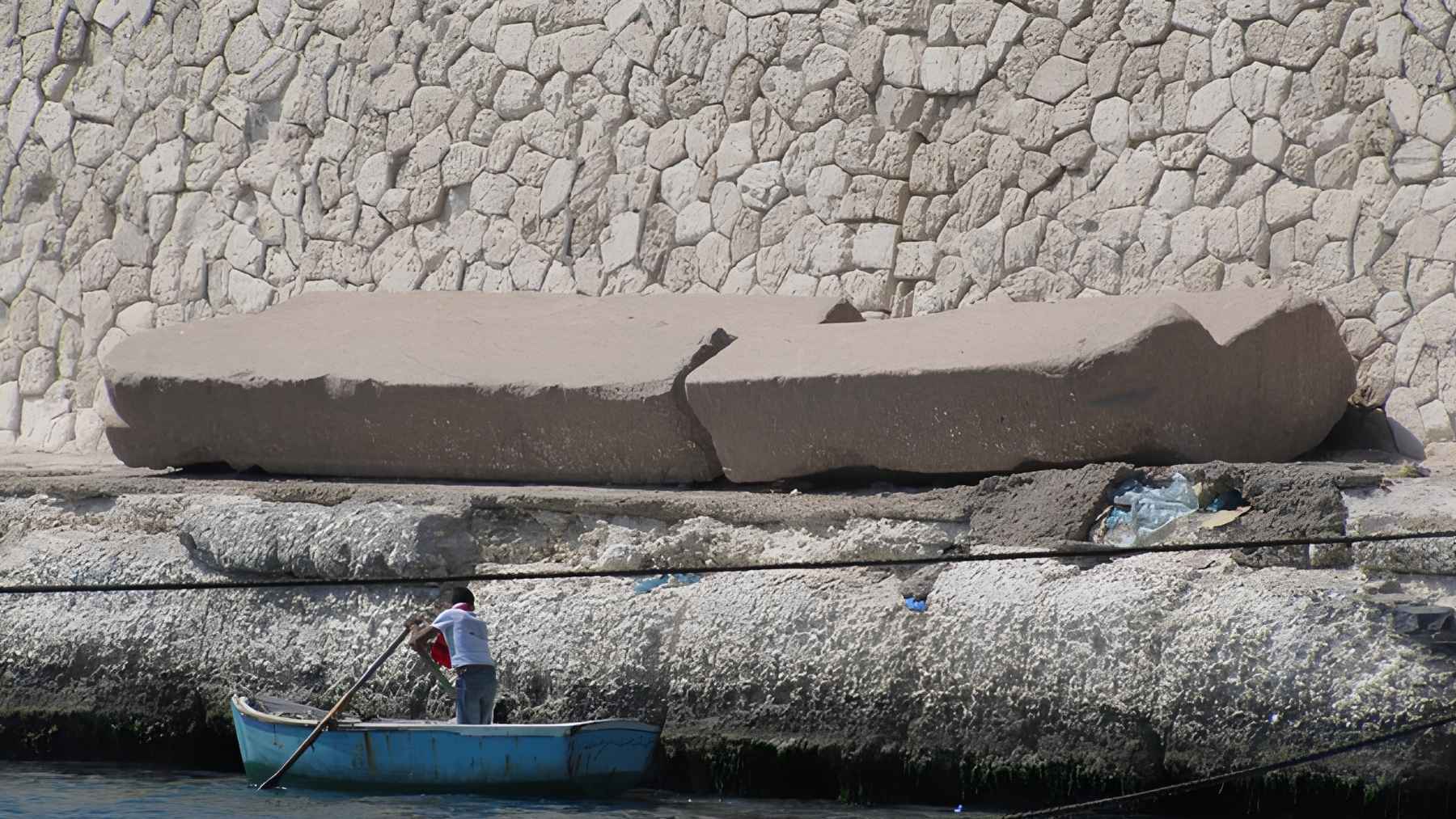 Large ancient stone fragment from the Lighthouse of Alexandria resting near the Mediterranean waterfront