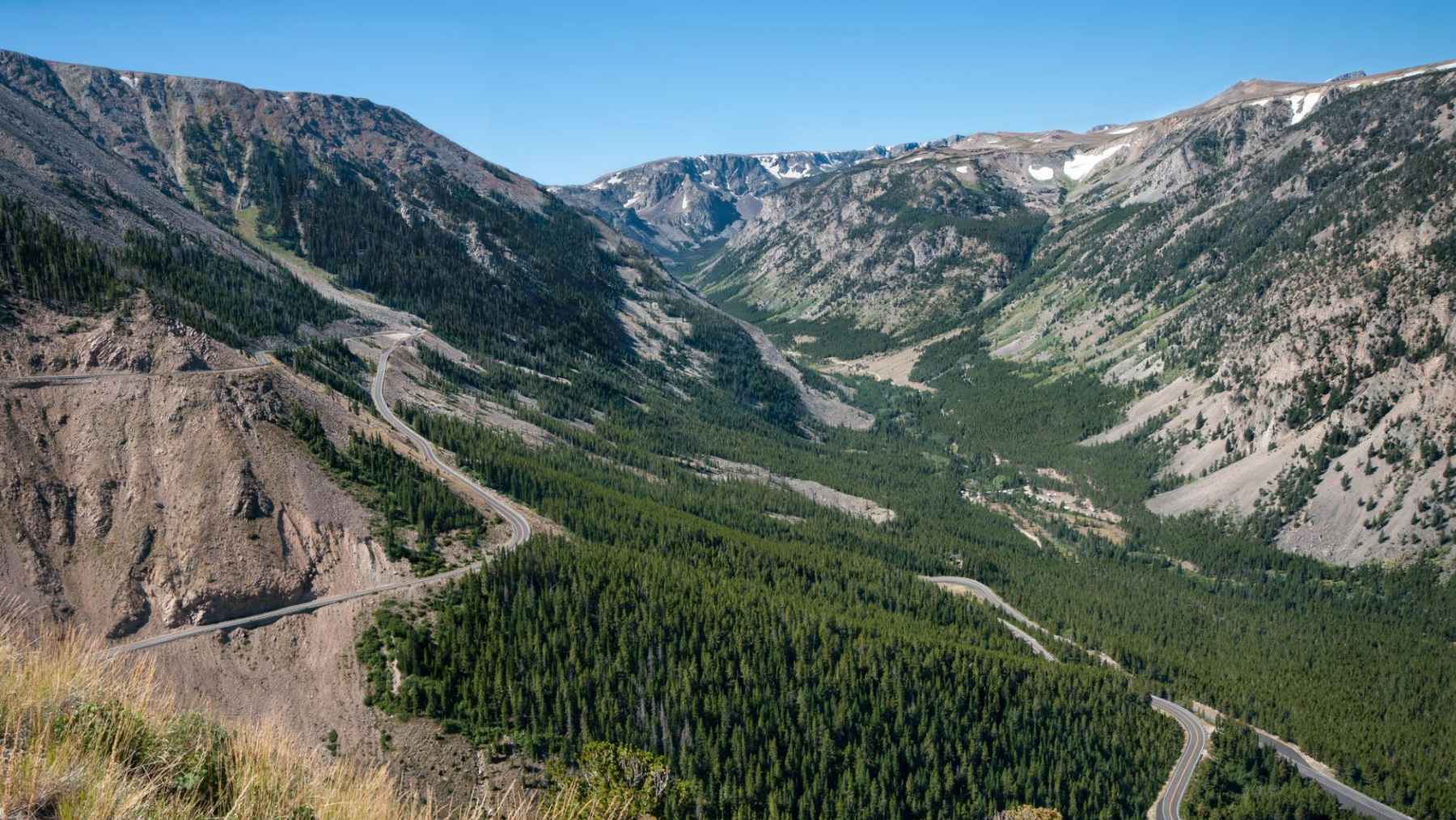 Winding section of Beartooth Highway crossing a mountain valley on the route toward Yellowstone National Park.