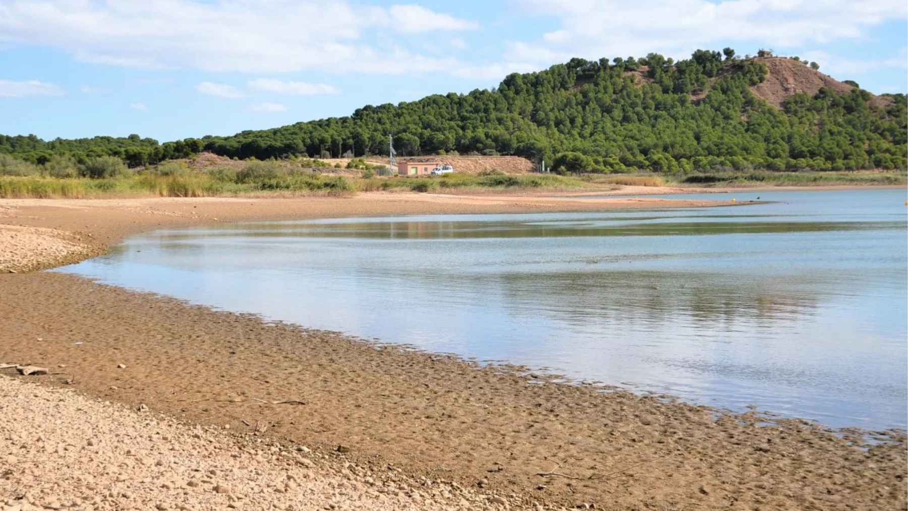 Low water levels at El Perdiguero reservoir in La Rioja exposing dry shorelines and shrinking aquatic habitat