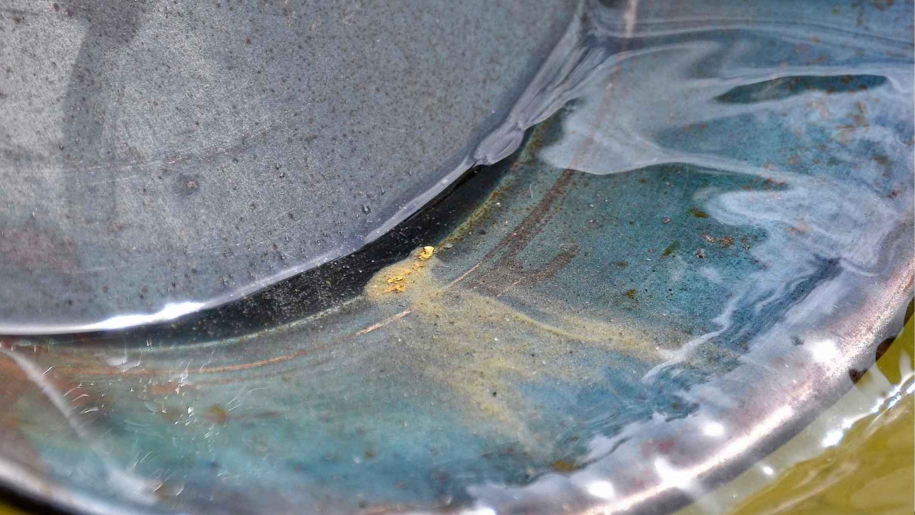 ECOnews 1 Small gold particles visible in a water sample, illustrating trace amounts of gold found in seawater.