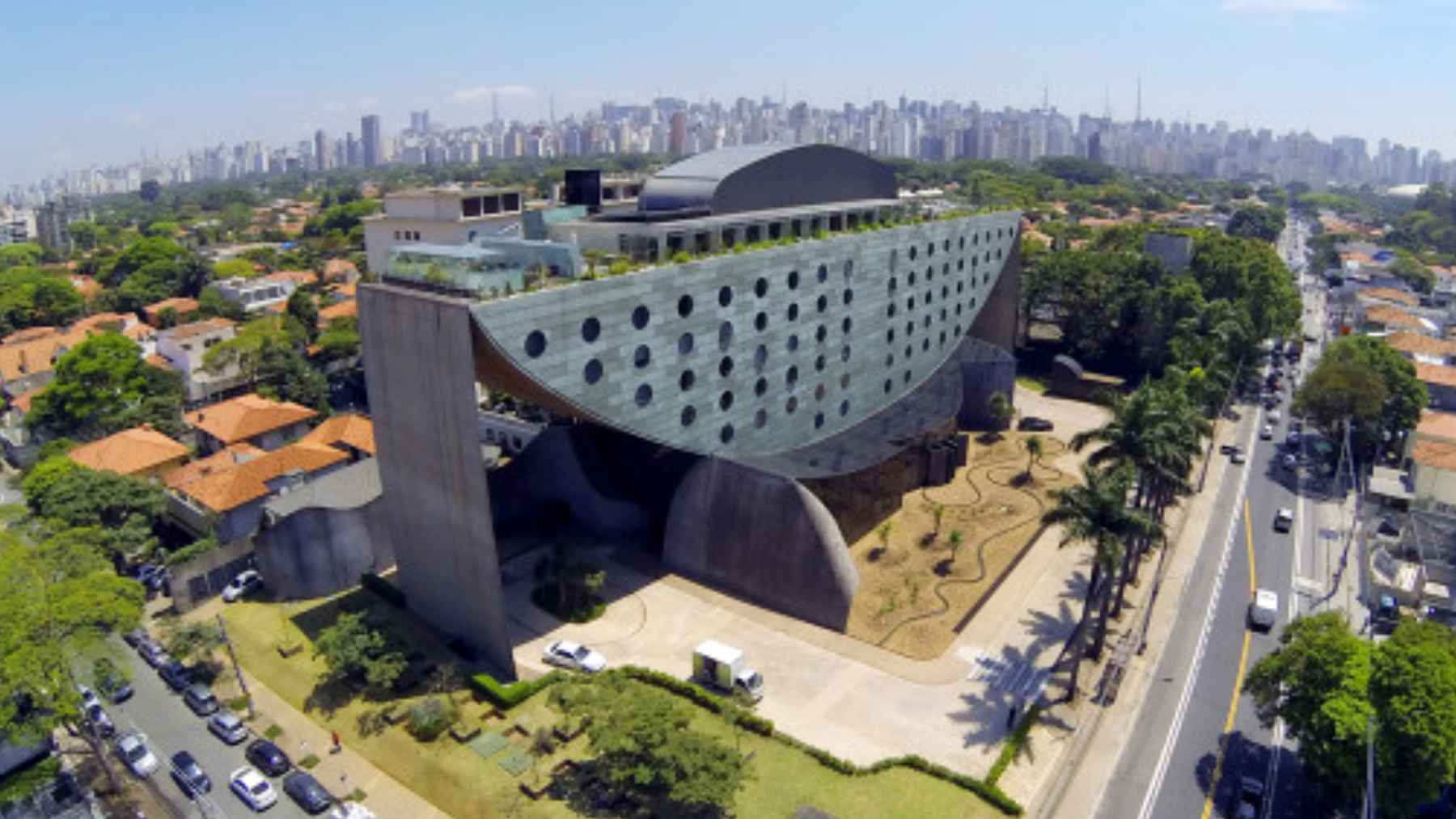 Aerial view of Hotel Unique in São Paulo, an upside-down ship-shaped building with round windows and exposed concrete.