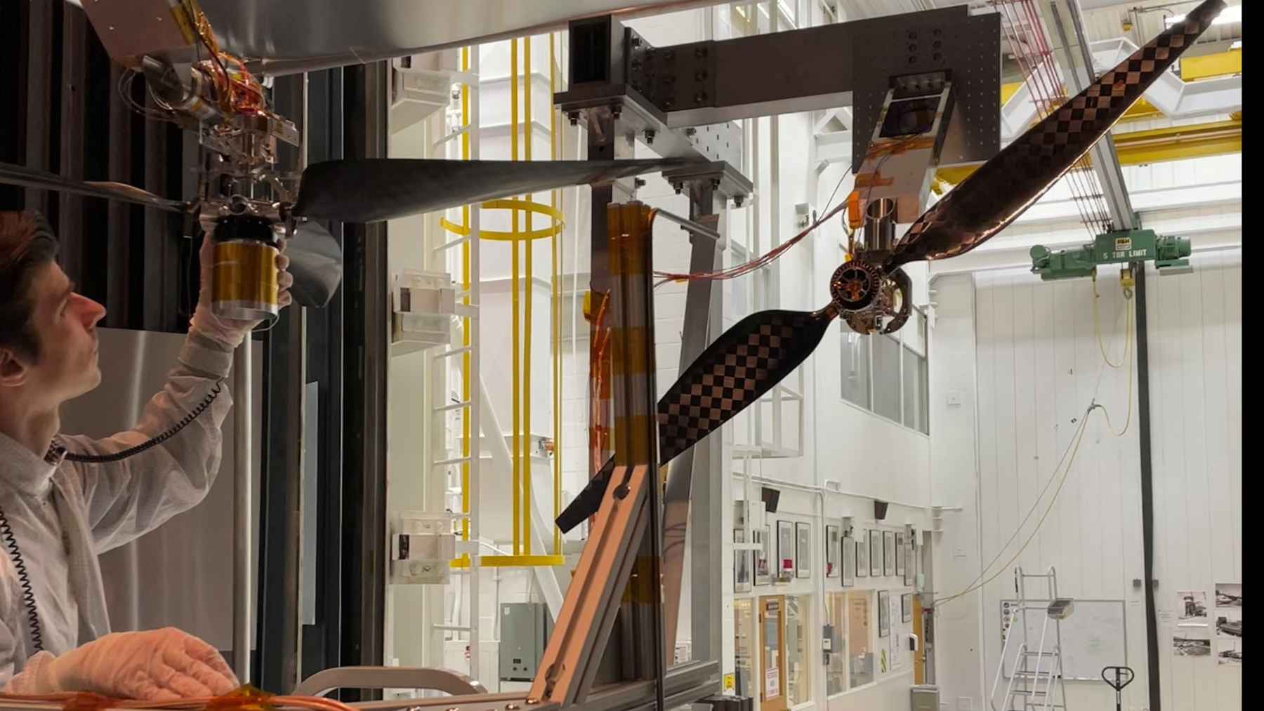 NASA engineer testing next-generation Mars helicopter rotor blades inside a JPL laboratory chamber.